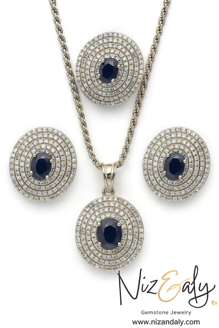 Niz & Aly Celestial Sapphire pendant and earring set featuring deep blue oval sapphires with concentric diamond halos.