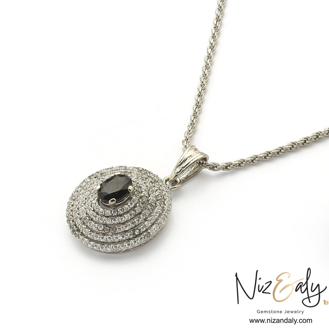 Niz & Aly Celestial Sapphire pendant necklace featuring a deep blue oval gemstone surrounded by concentric crystal halos.