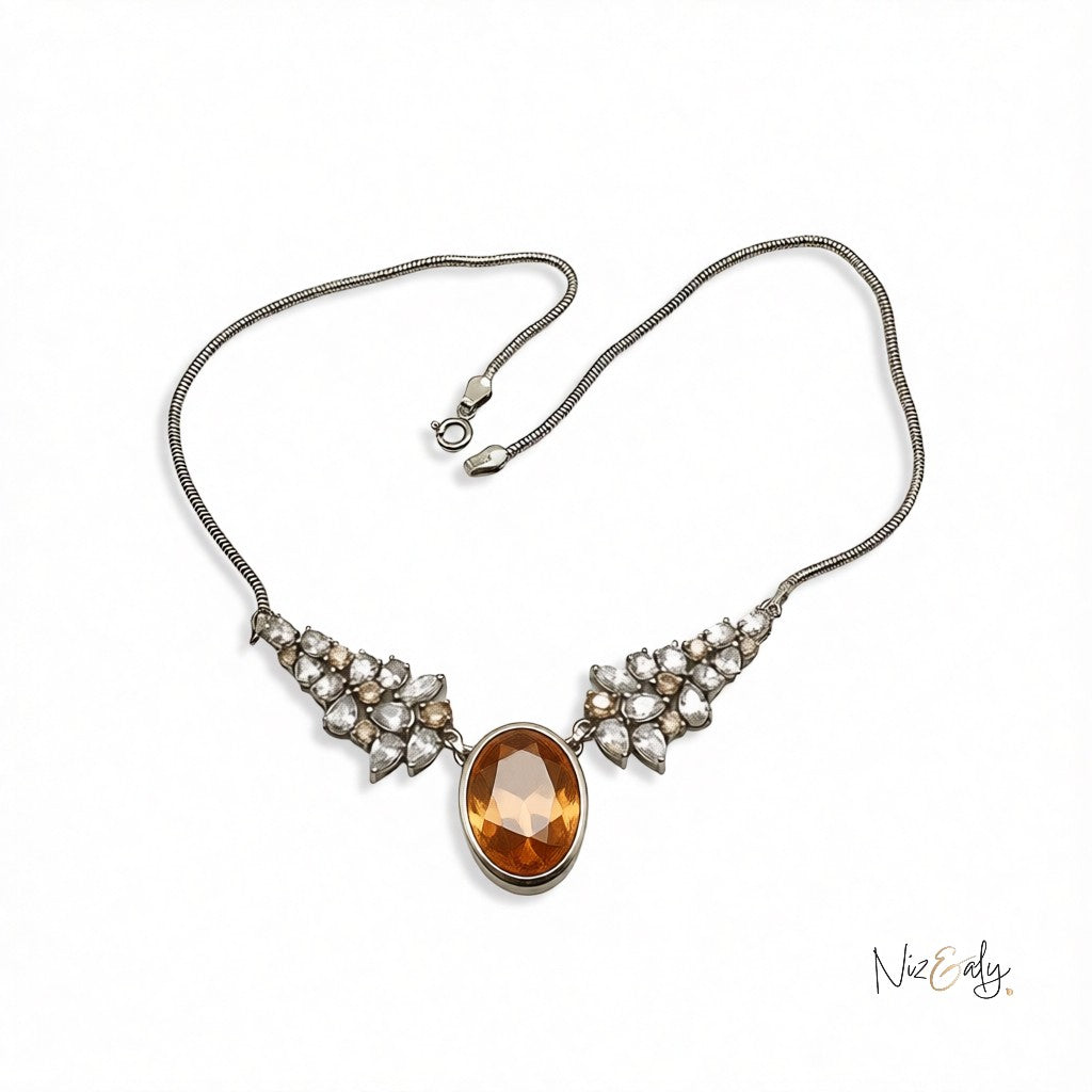 Niz & Aly Golden Hour statement necklace featuring a large oval champagne zirconia pendant with crystal accents.