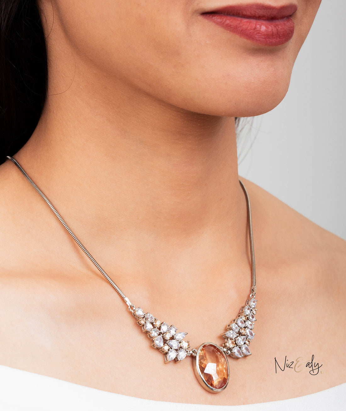 Niz & Aly Golden Hour statement necklace featuring a champagne-hued zirconia pendant on a silver-toned snake chain.
