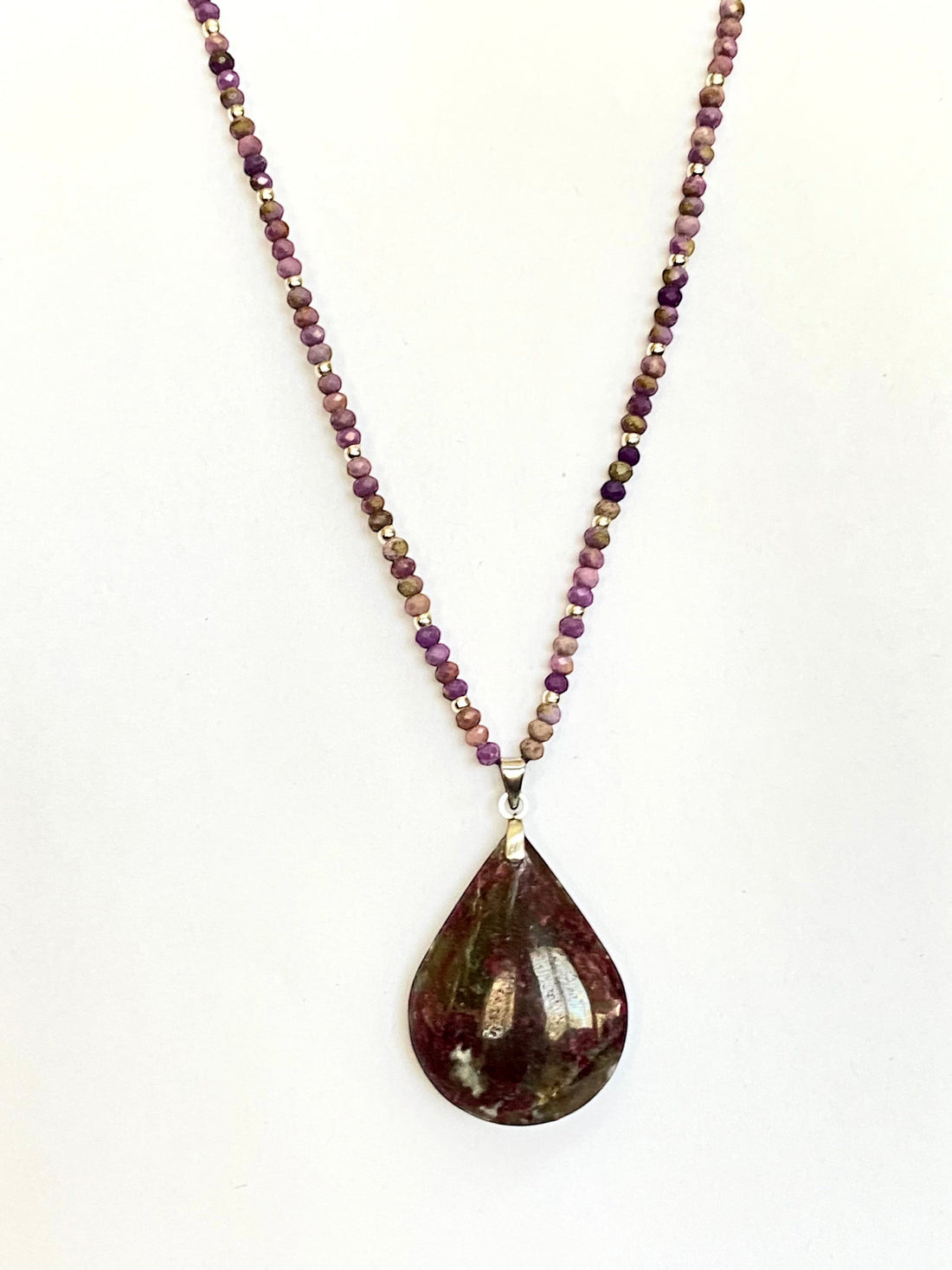 Niz & Aly teardrop Charoite pendant necklace with purple, lavender, and beige beaded chain on a white background.