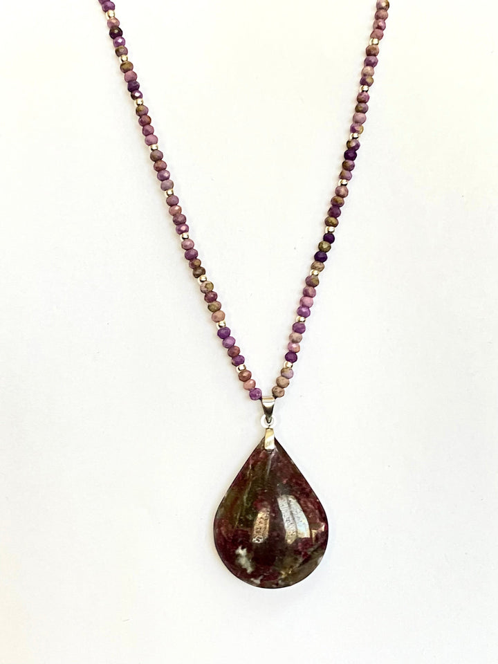 Niz & Aly teardrop Charoite pendant necklace with purple, lavender, and beige beaded chain on a white background.