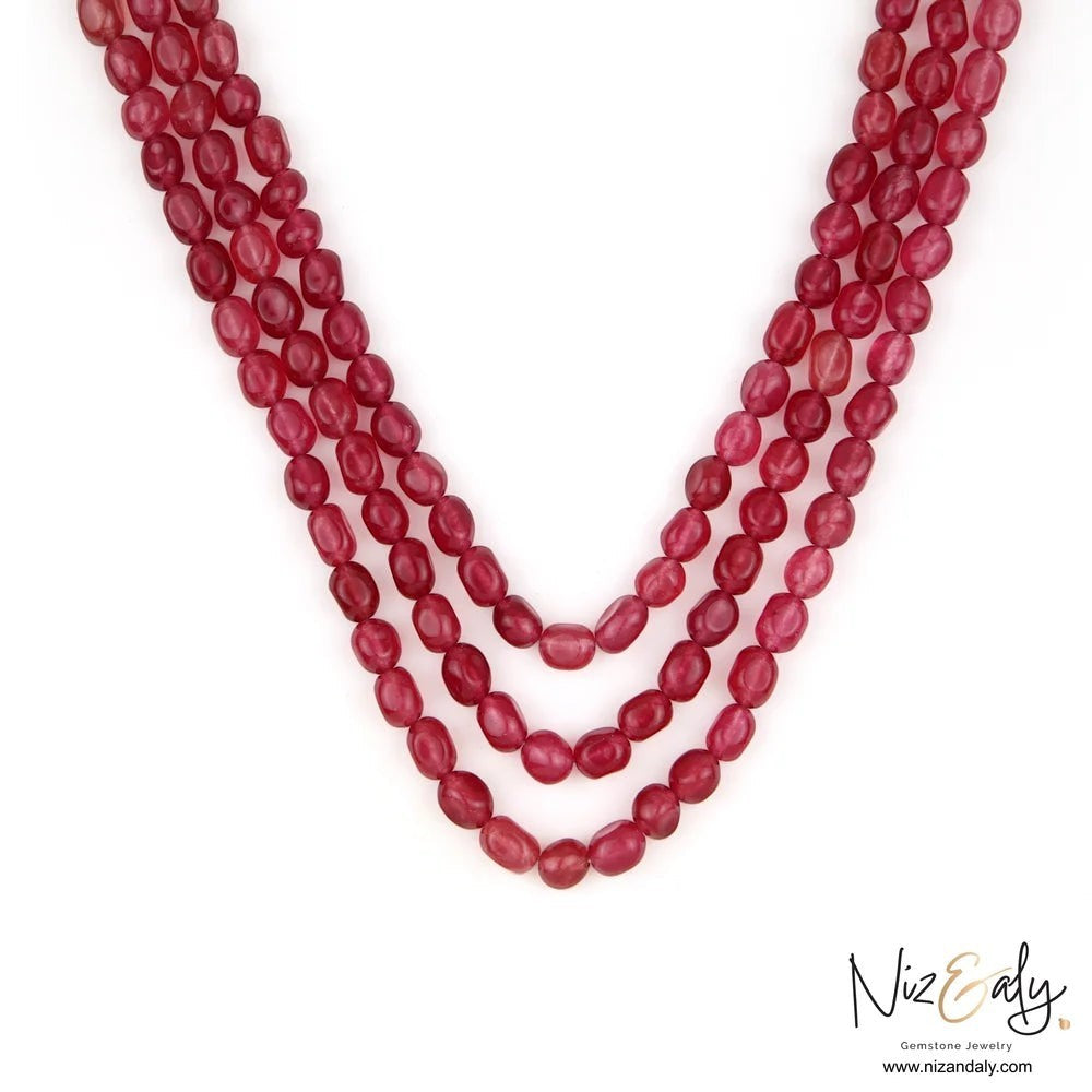 Niz & Aly triple strand necklace featuring polished translucent cherry quartz beads in a fluid rope design.