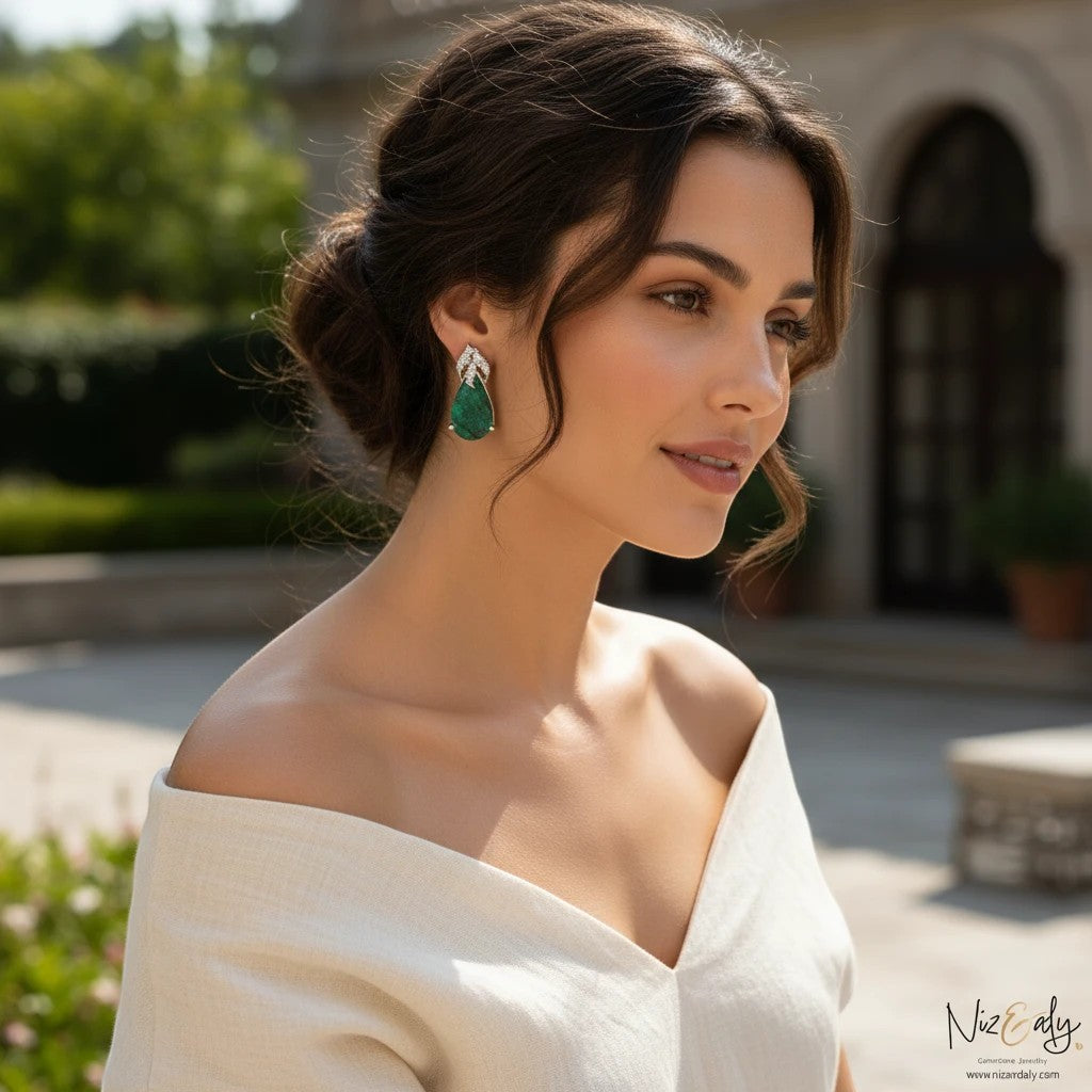 Niz & Aly pear-shaped green chrysocolla stud earrings in sterling silver worn by a woman in a white top