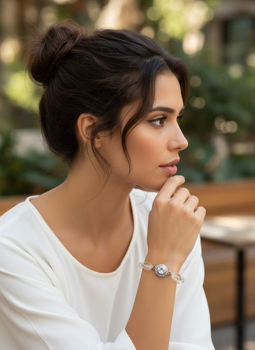 Niz & Aly clear quartz beaded bracelet worn by a woman with a bun, featuring a central crystal charm.