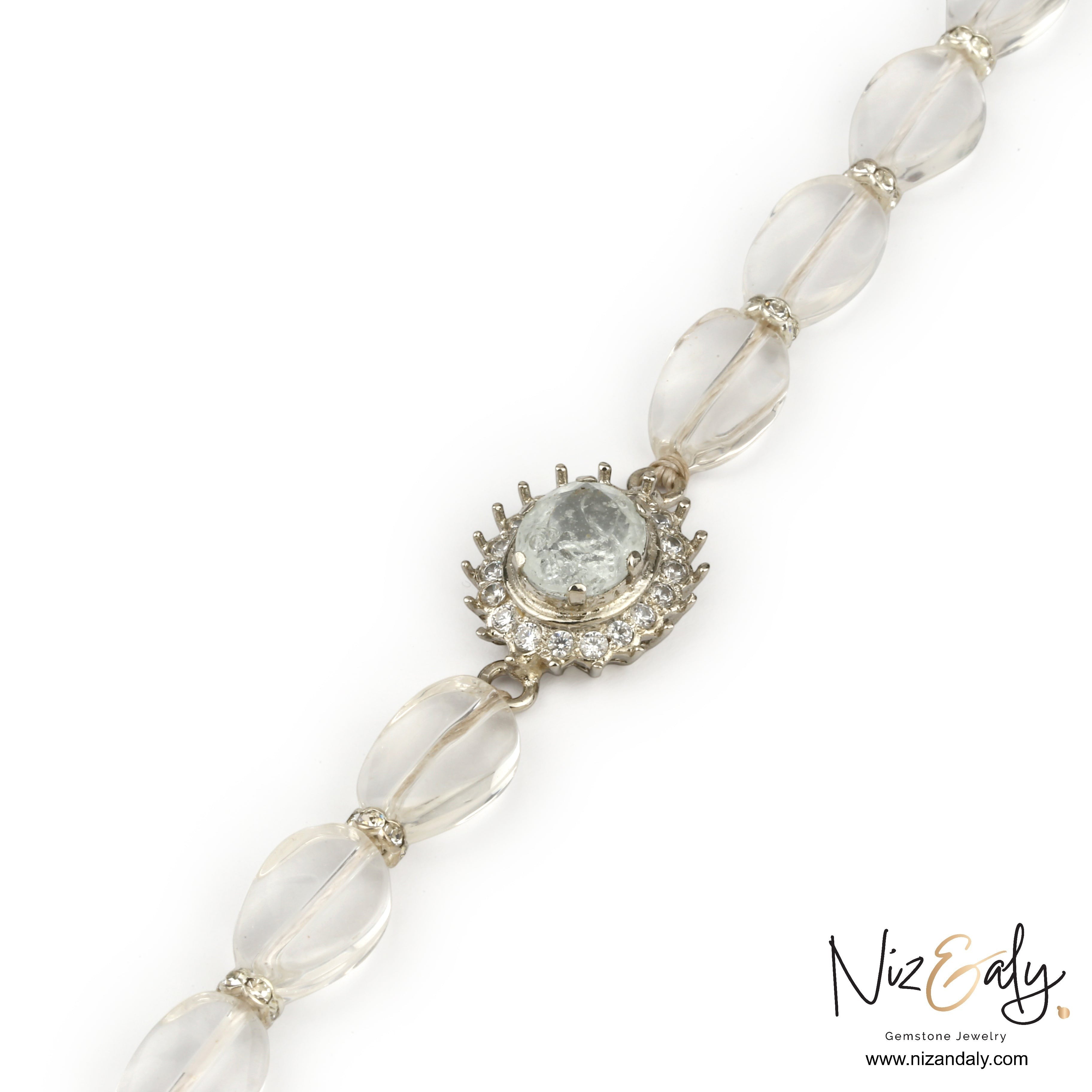 Niz & Aly clear quartz beaded bracelet with a central oval crystal charm and sparkling stone accents.