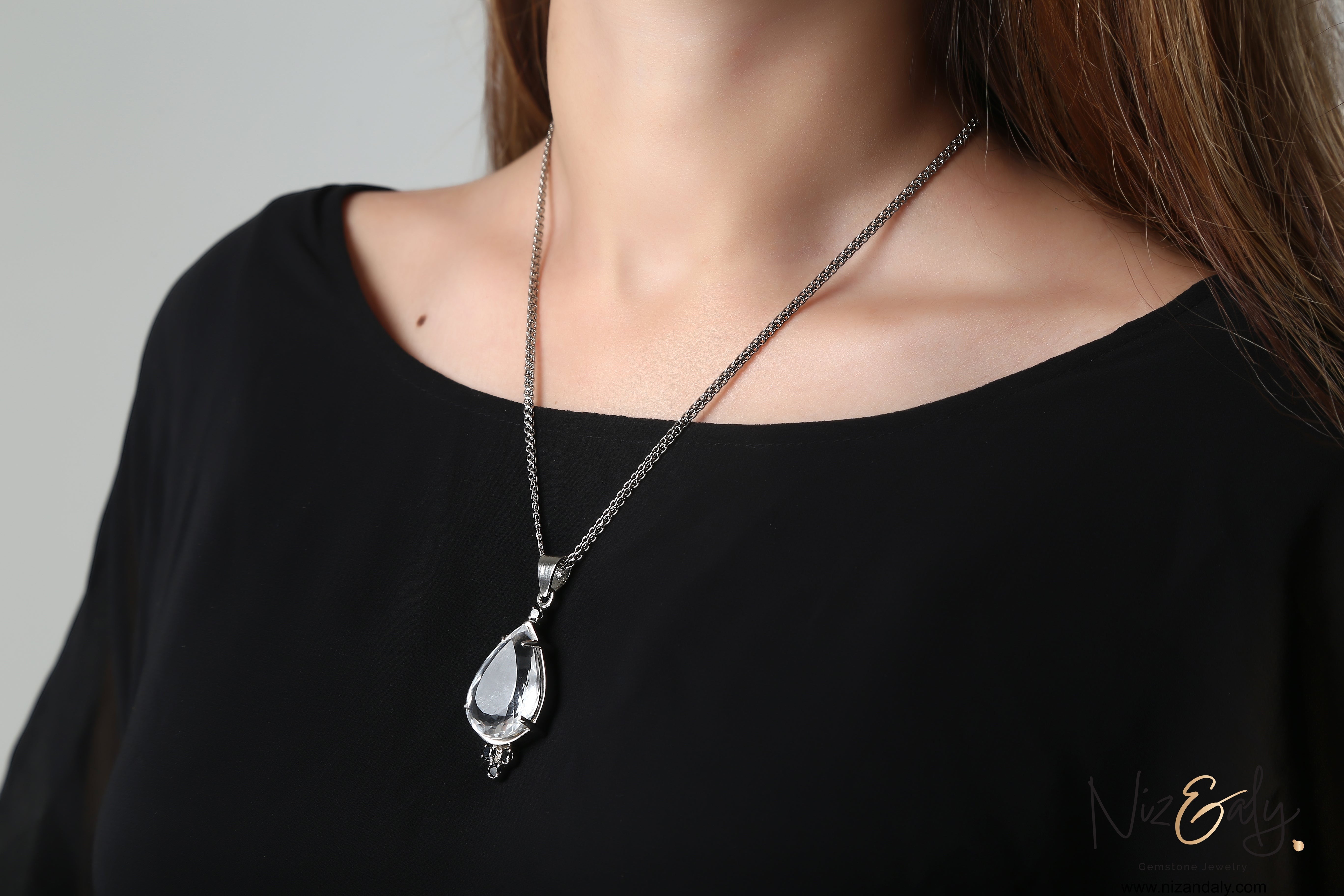 Niz & Aly Moonlight Whisper pendant featuring a clear quartz drop and black onyx stones on a silver chain