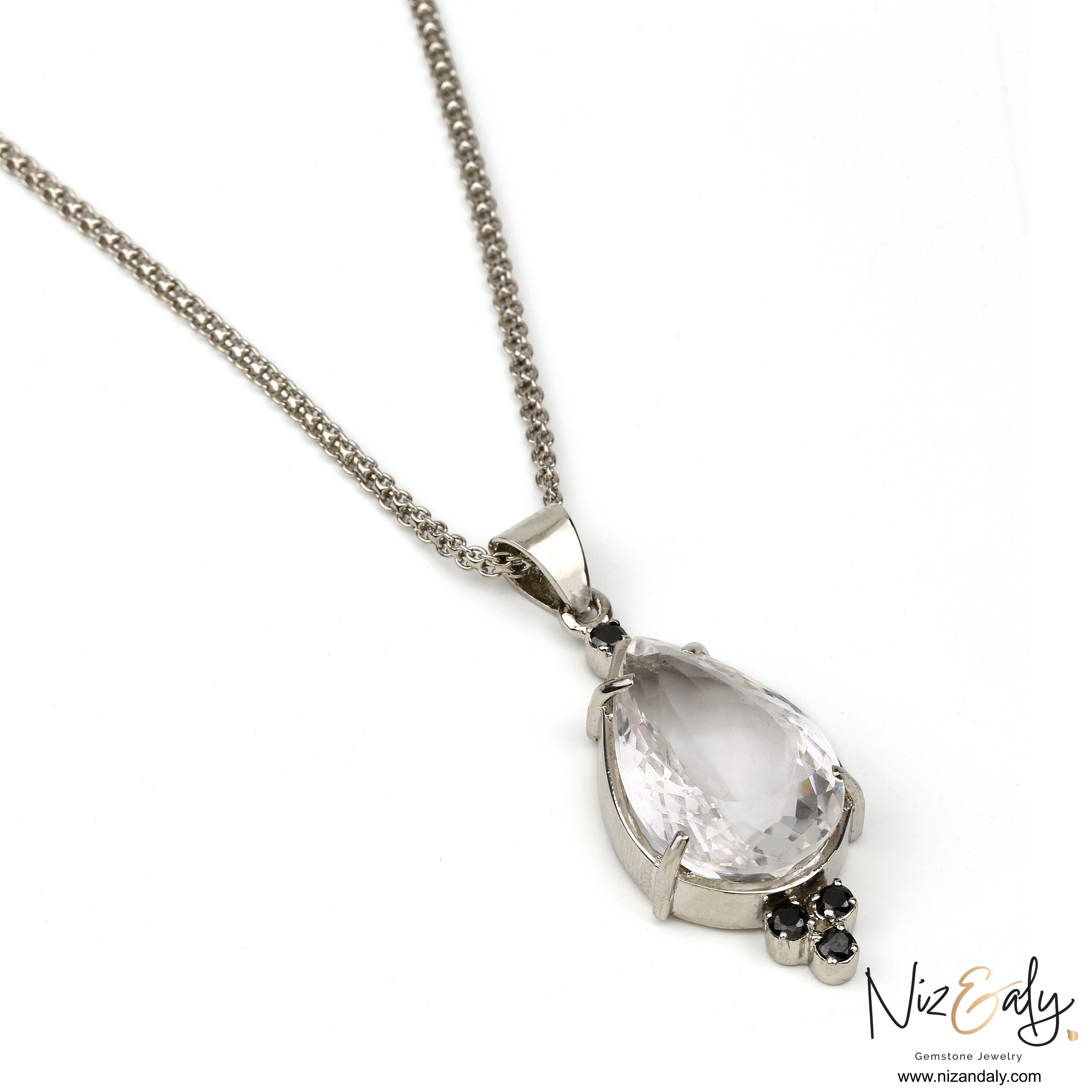Niz & Aly teardrop clear quartz pendant with three black onyx stones on a silver chain against a white background.