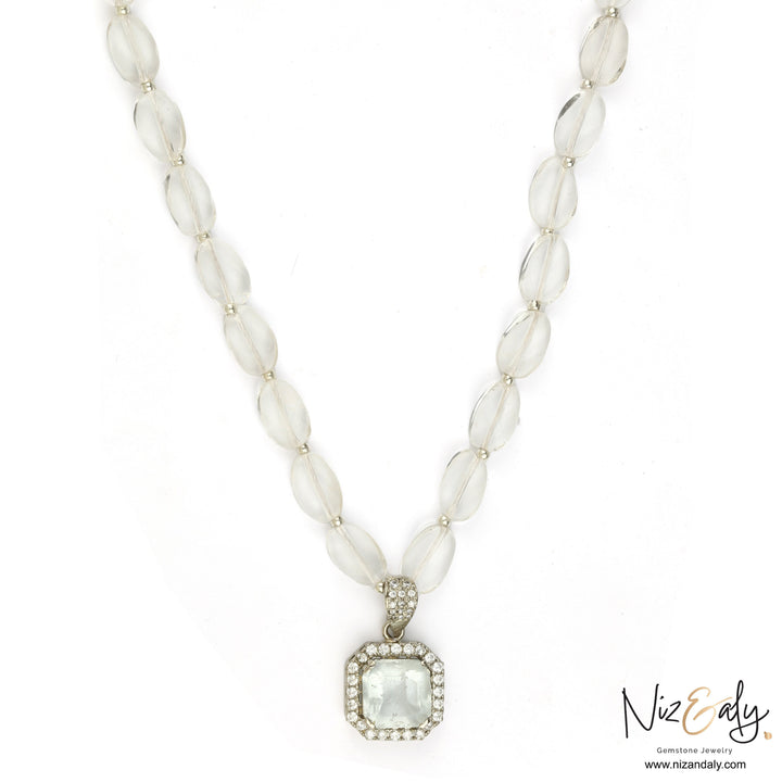 Niz & Aly clear quartz pendant necklace with icy quartz beads and a diamond-accented frame on a white background.