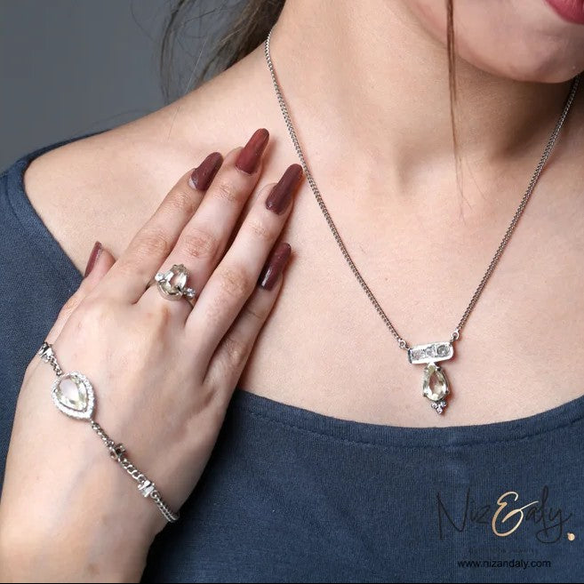Niz & Aly clear quartz pendant necklace, bracelet, and ring set in 925 sterling silver worn by a woman