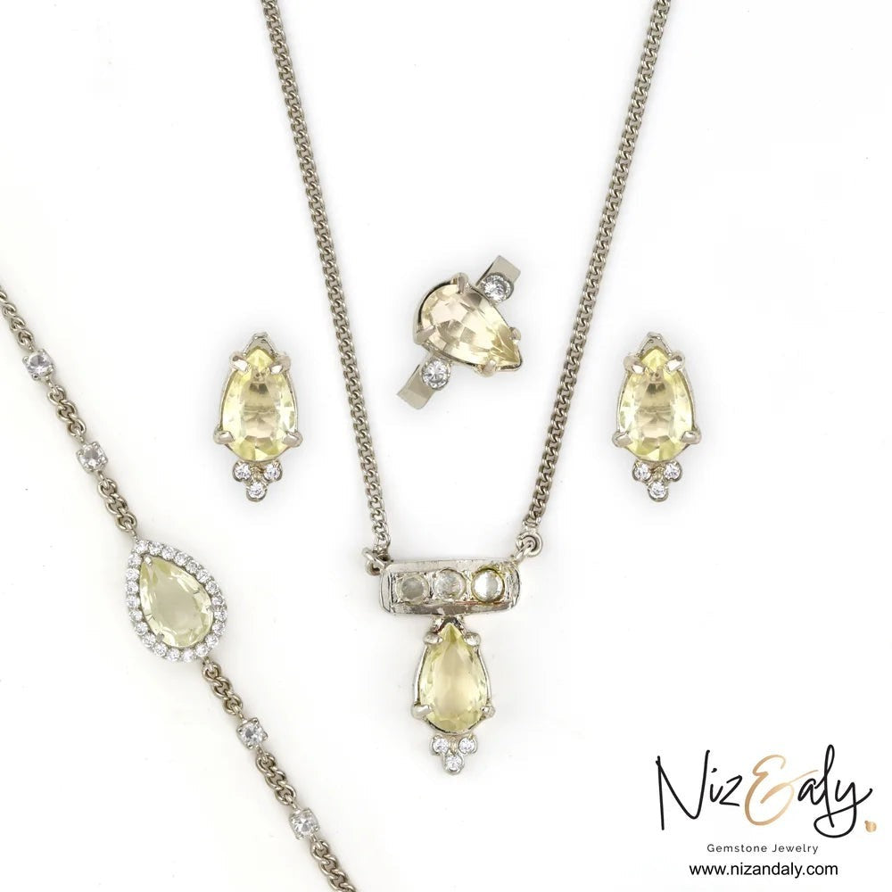 Niz & Aly clear quartz jewelry set featuring a pendant necklace, earrings, bracelet, and ring in 925 sterling silver.