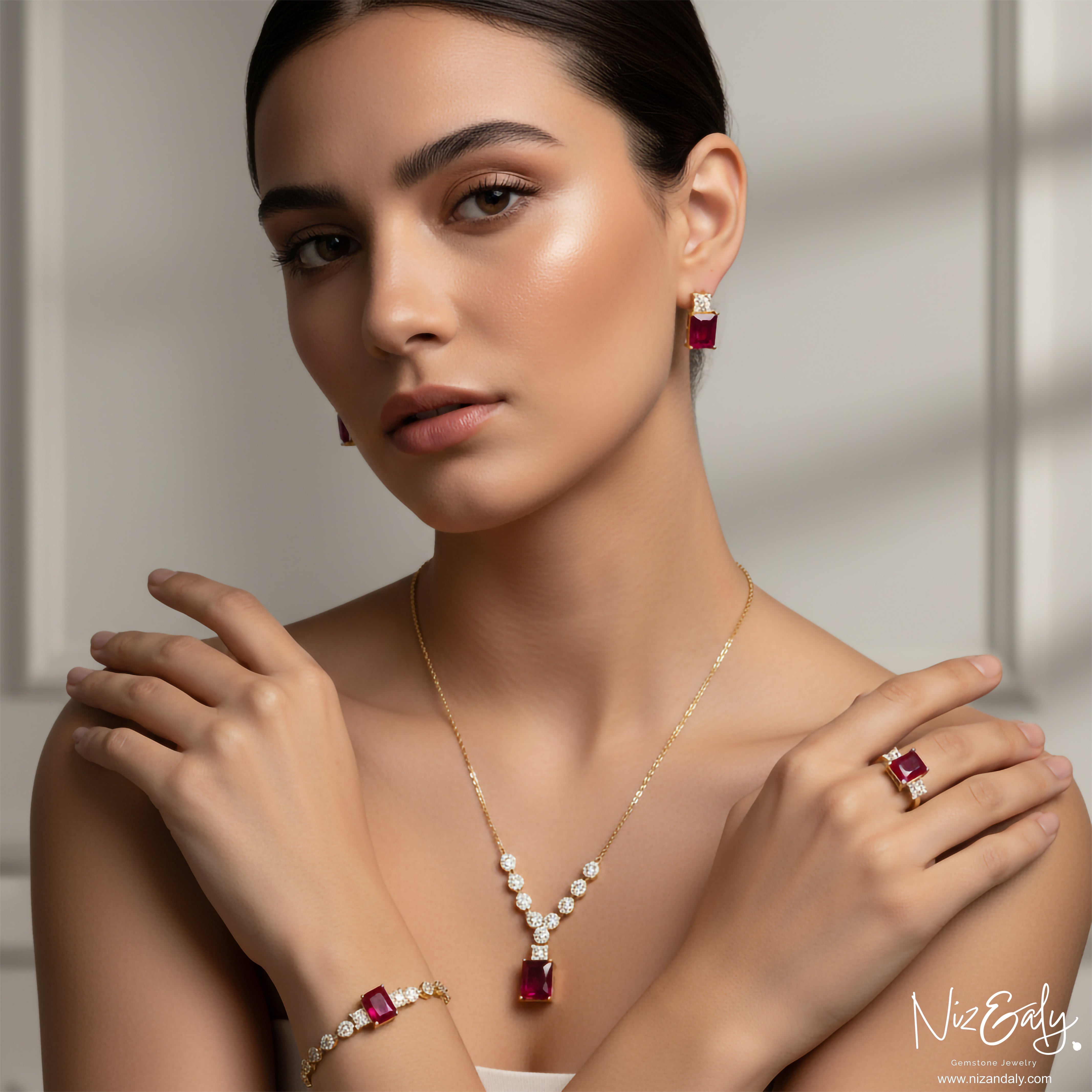 Niz & Aly composite ruby jewelry set featuring a pendant, earrings, bracelet, and ring on a model in studio lighting.