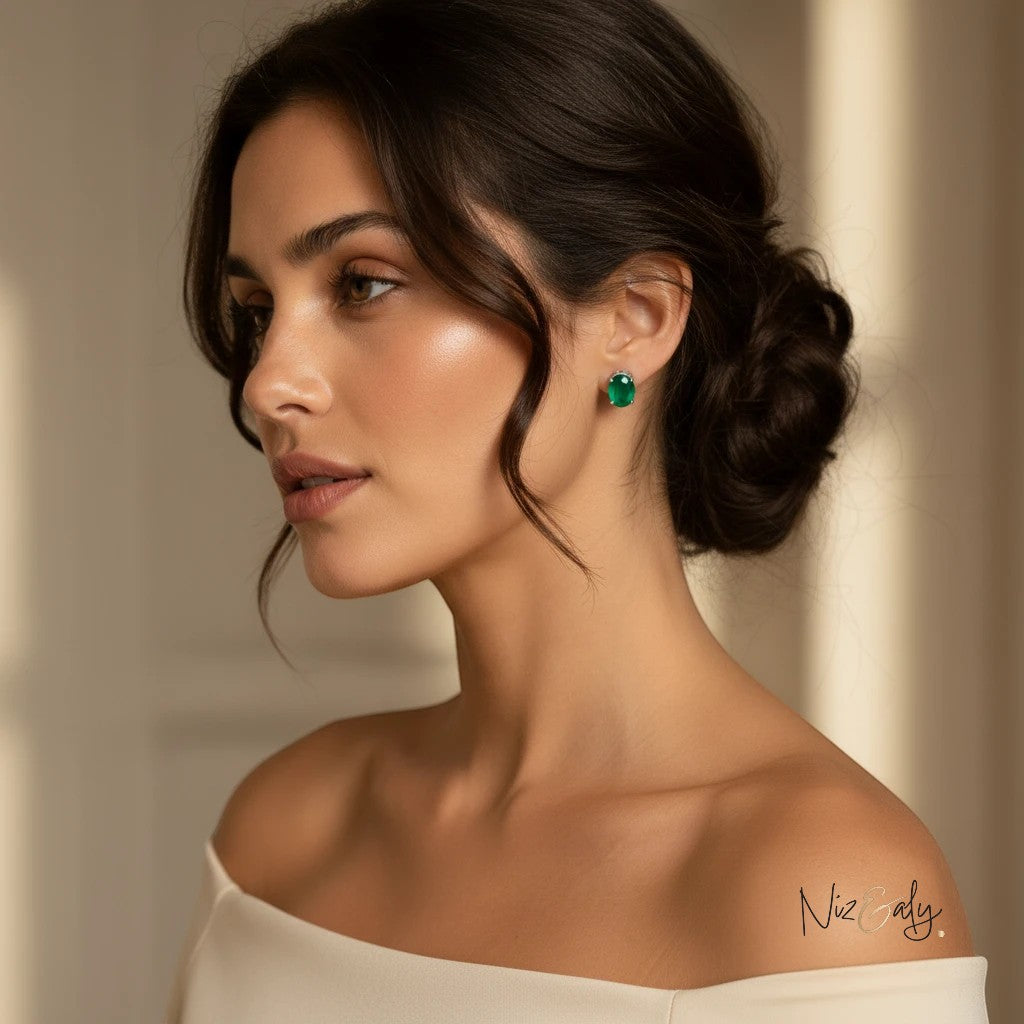 Niz & Aly dainty emerald ear studs worn by a woman with an elegant updo, highlighting the vibrant green gemstone.