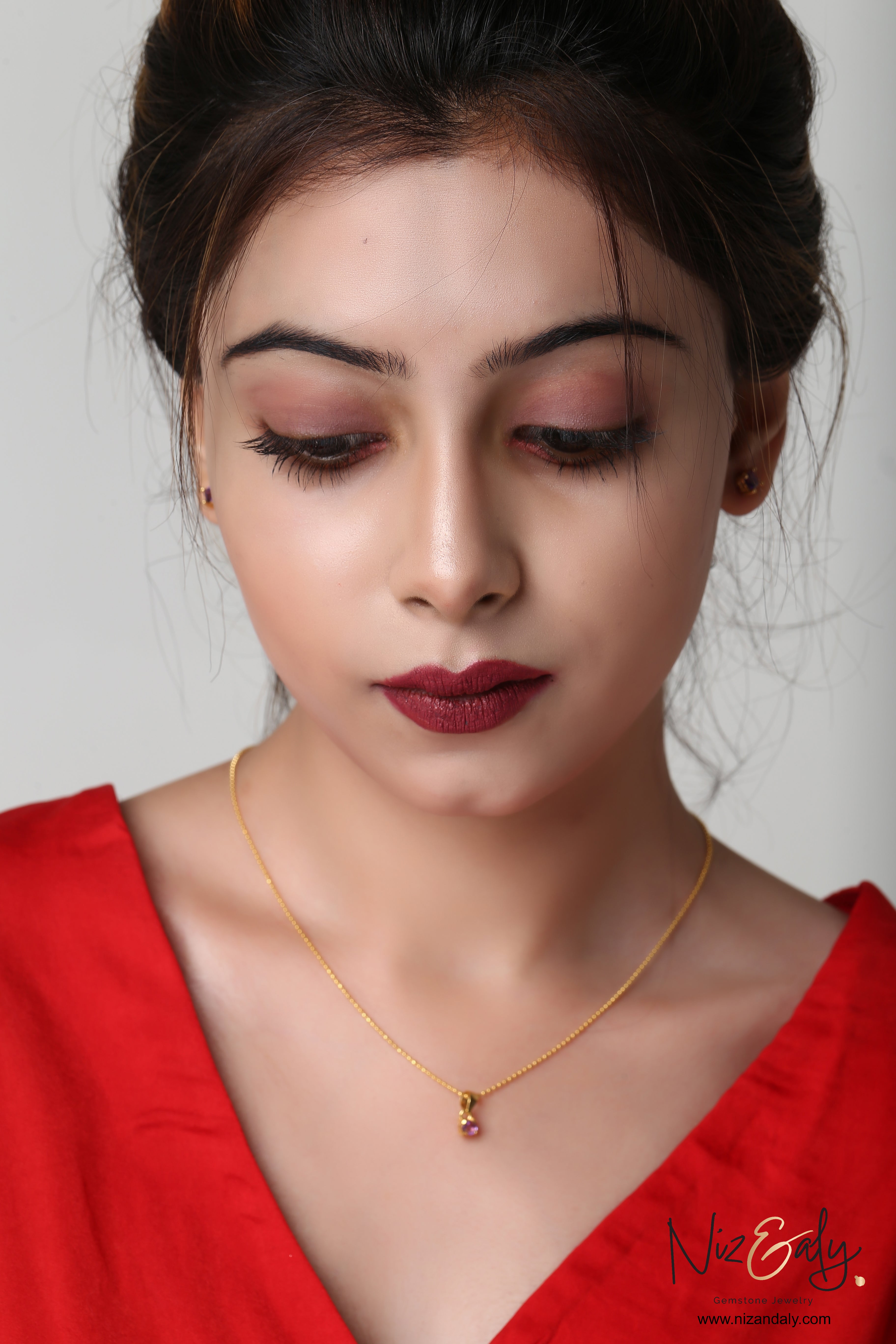 Niz & Aly dainty gold-plated necklace with a square amethyst pendant worn by a woman in a red top