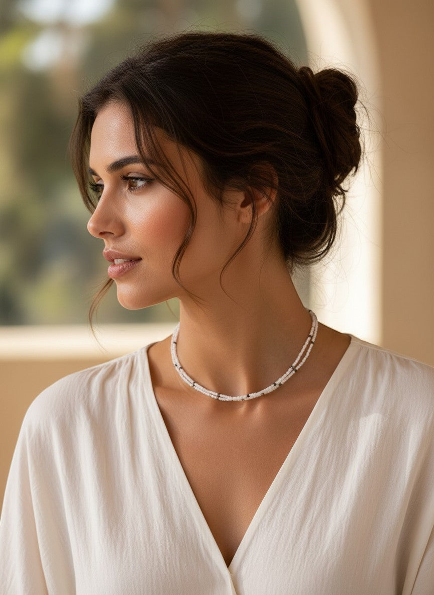 Niz & Aly dainty double-strand milky quartz necklace worn by a woman in a white blouse