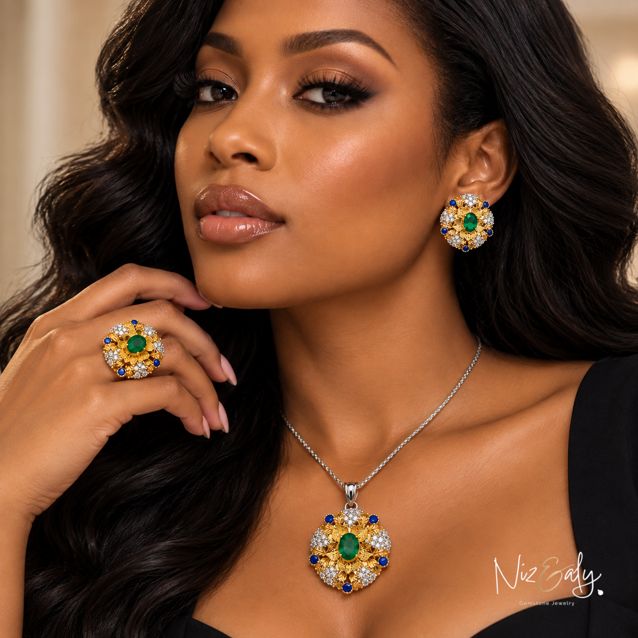 Niz & Aly emerald jewelry set featuring a necklace, ring, and earrings with gold bezel settings and blue accents.