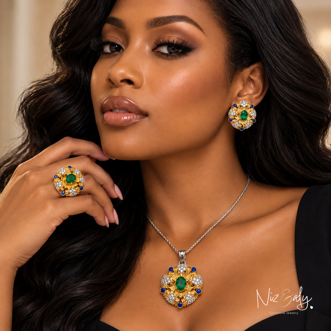 Niz & Aly emerald jewelry set featuring a necklace, ring, and earrings with gold bezel settings and blue accents.