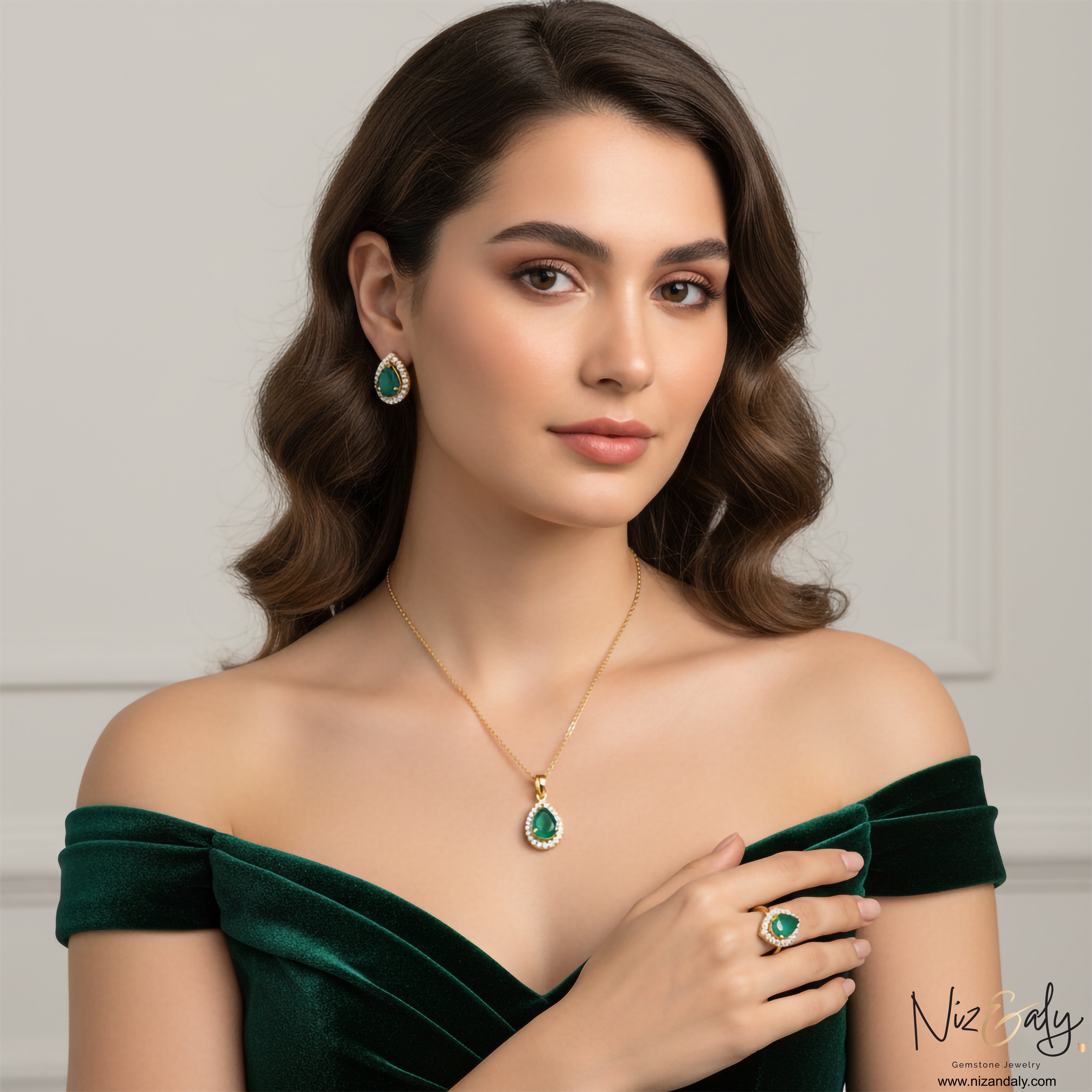 Niz & Aly natural teardrop emerald jewelry set with gold-plated sterling silver pendant, earrings, and ring on model.