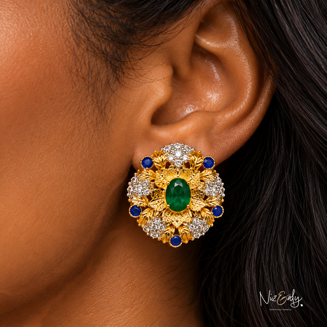 Niz & Aly emerald and sapphire floral gold stud earring with diamond accents worn on ear