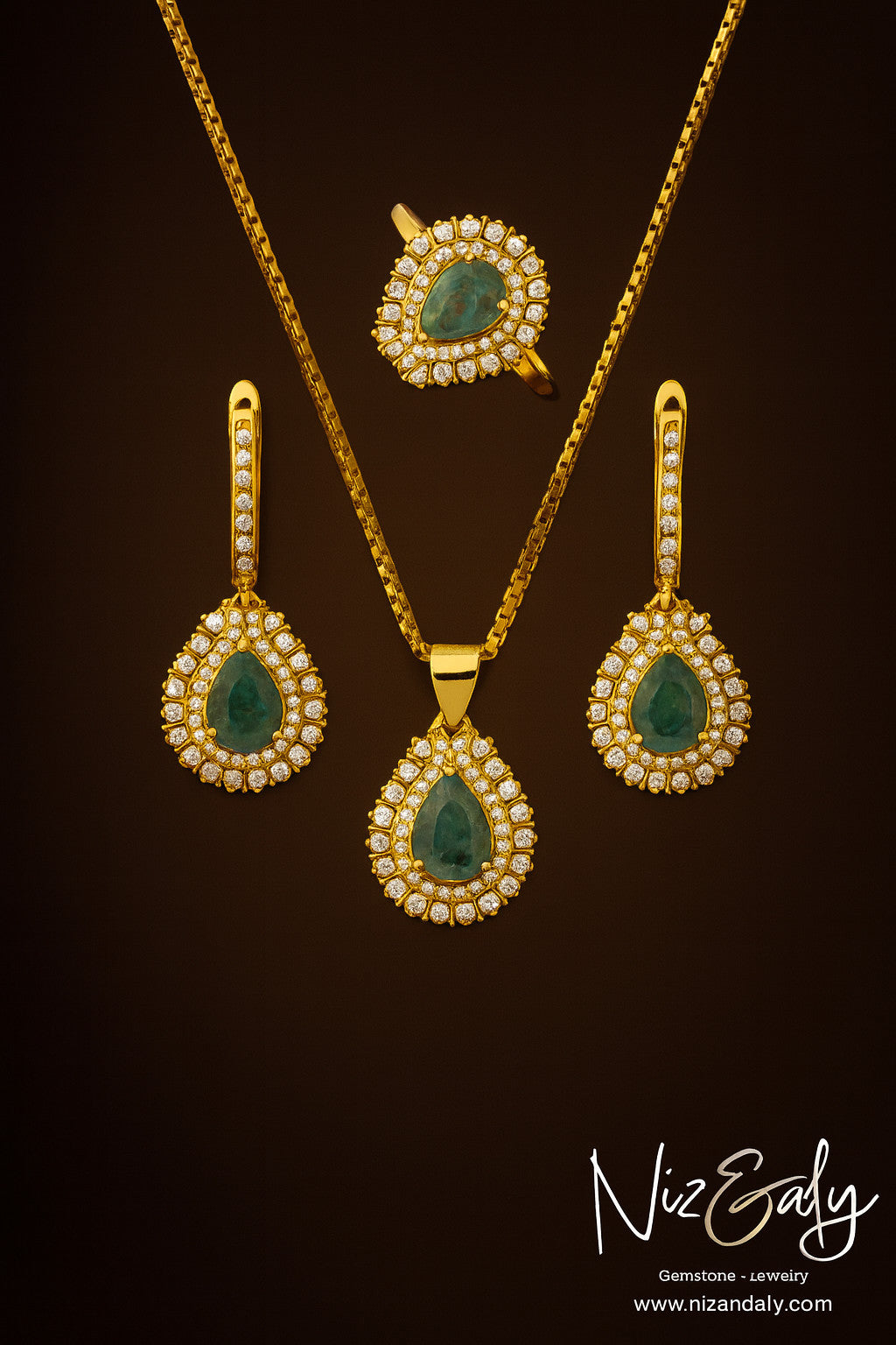 Niz & Aly Emerald Reverie jewelry set featuring teardrop natural emeralds in gold-plated silver with clear stone halos.