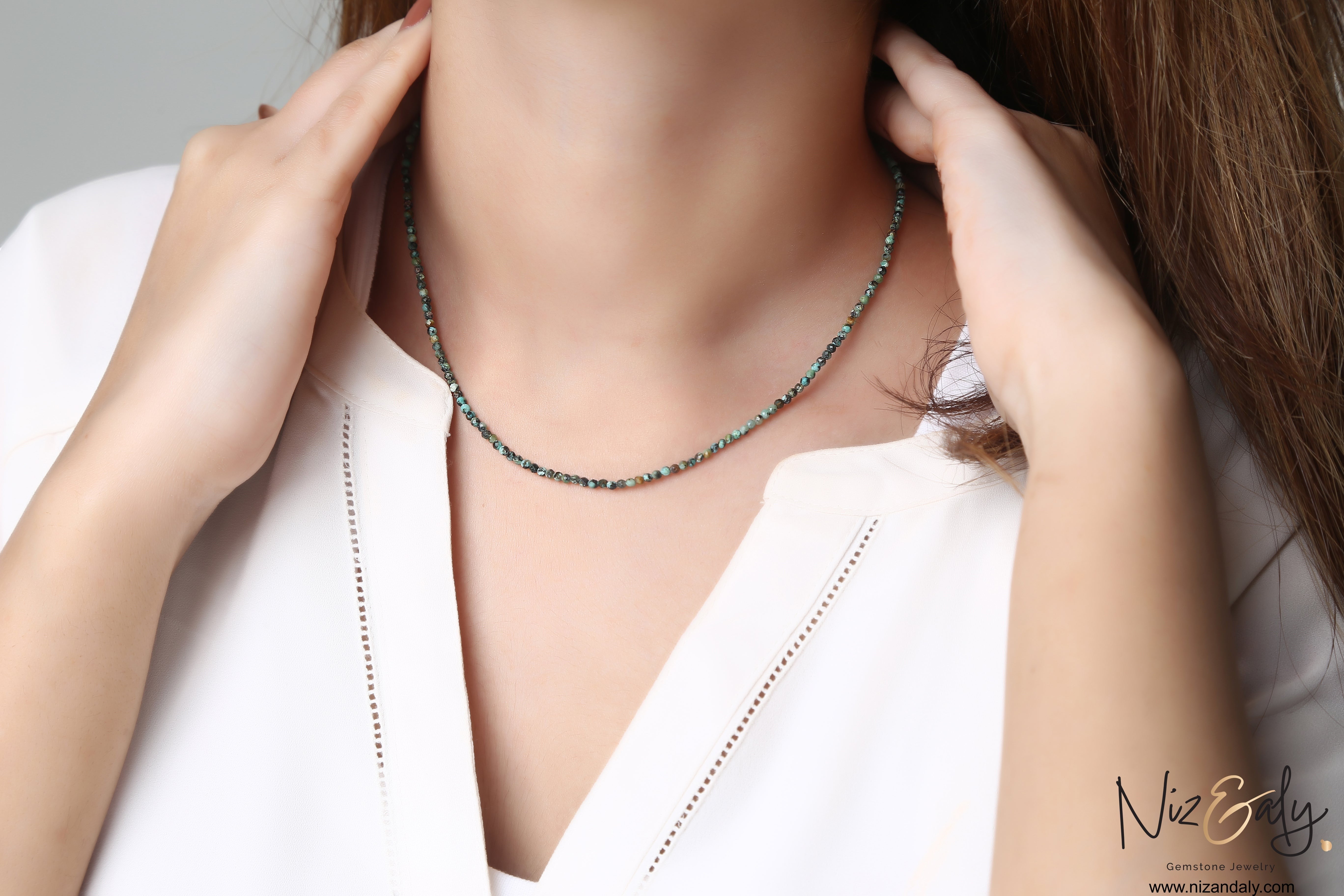 Niz & Aly dainty 16-inch necklace featuring 2mm faceted blue-green African turquoise beads on a woman's neck.