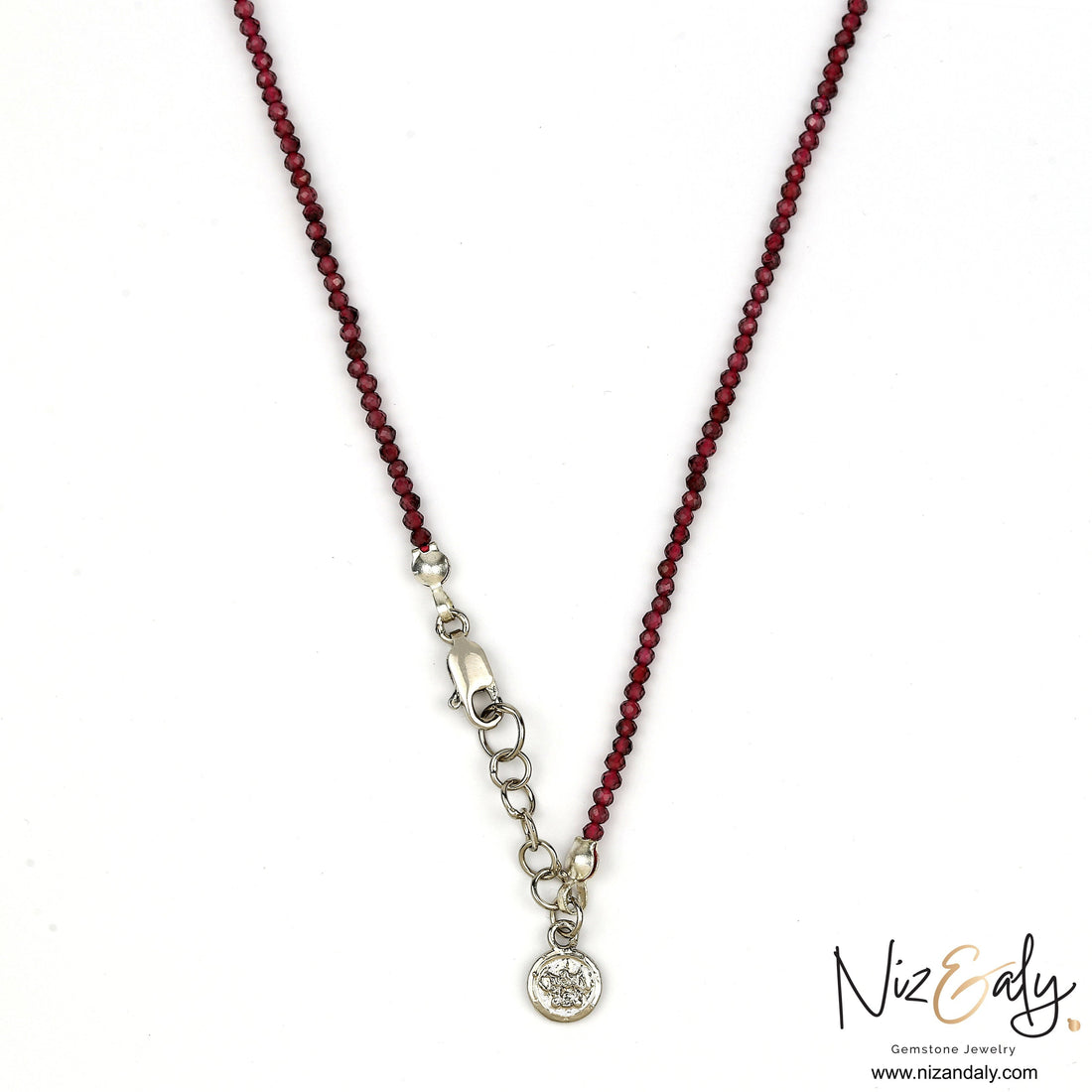 Niz & Aly dainty faceted almandine garnet bead necklace with a silver clasp and charm on a white background.