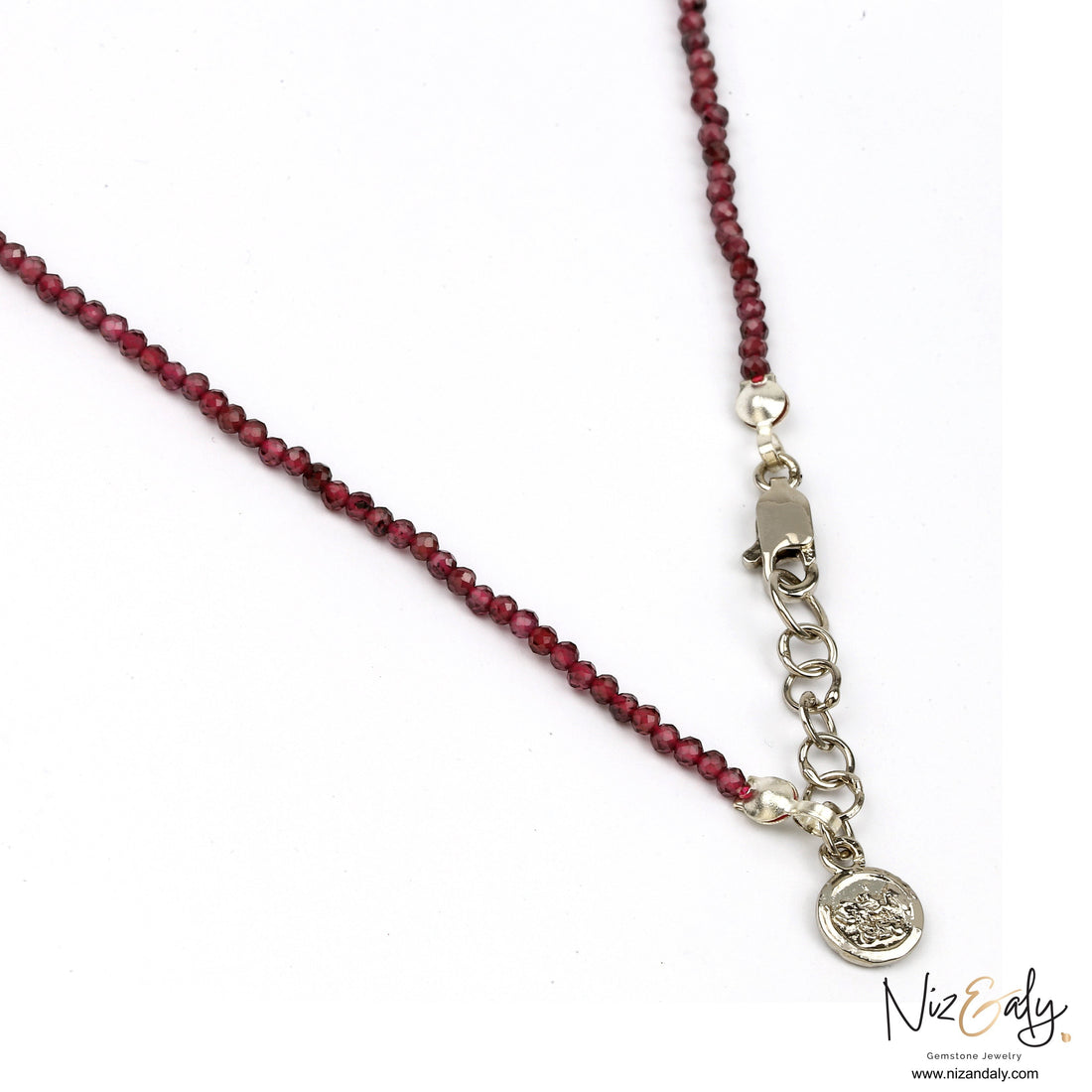 Niz & Aly dainty faceted almandine garnet bead necklace with a silver clasp and charm on a white background