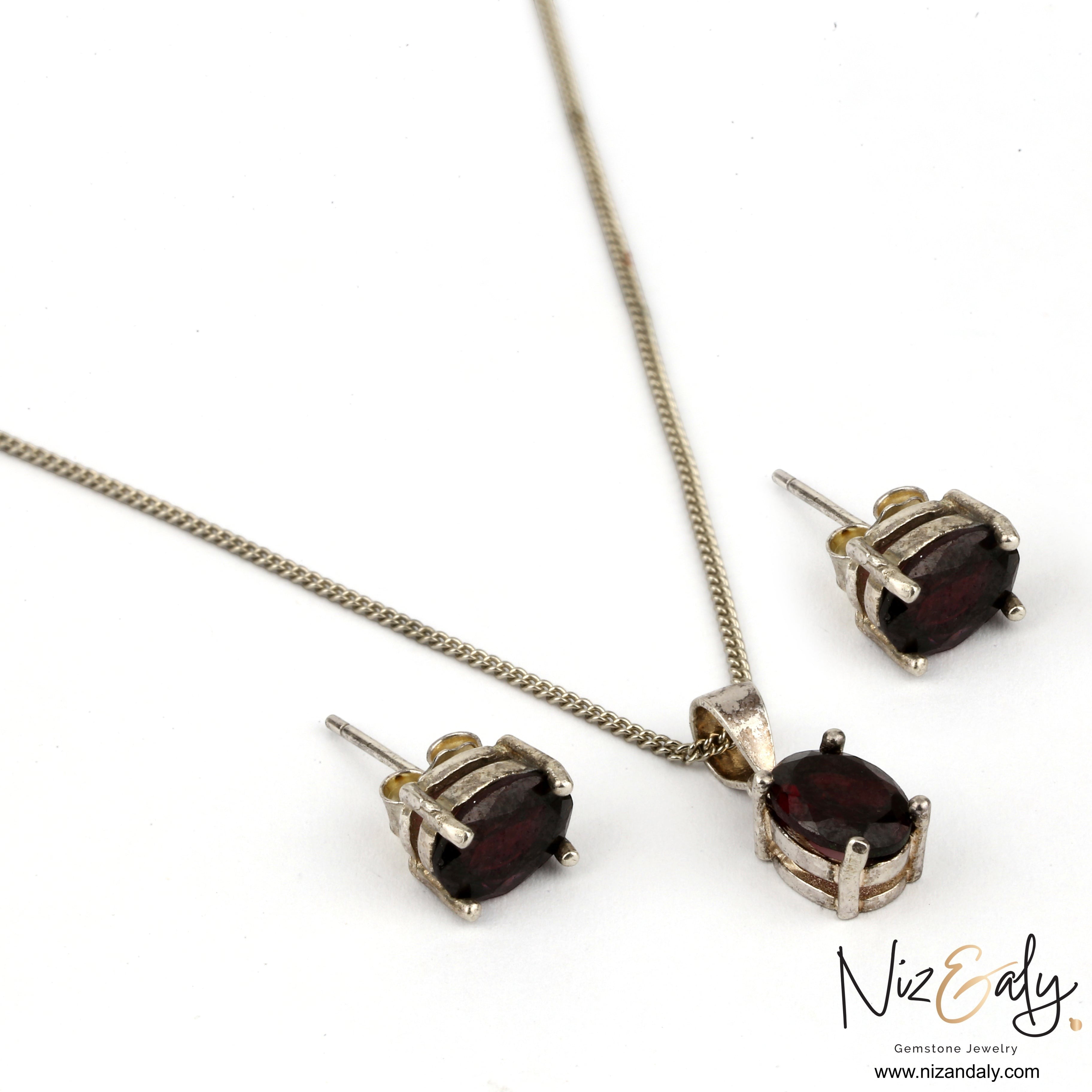 Niz & Aly garnet locket pendant and matching stud earrings set in silver with deep red oval gemstones