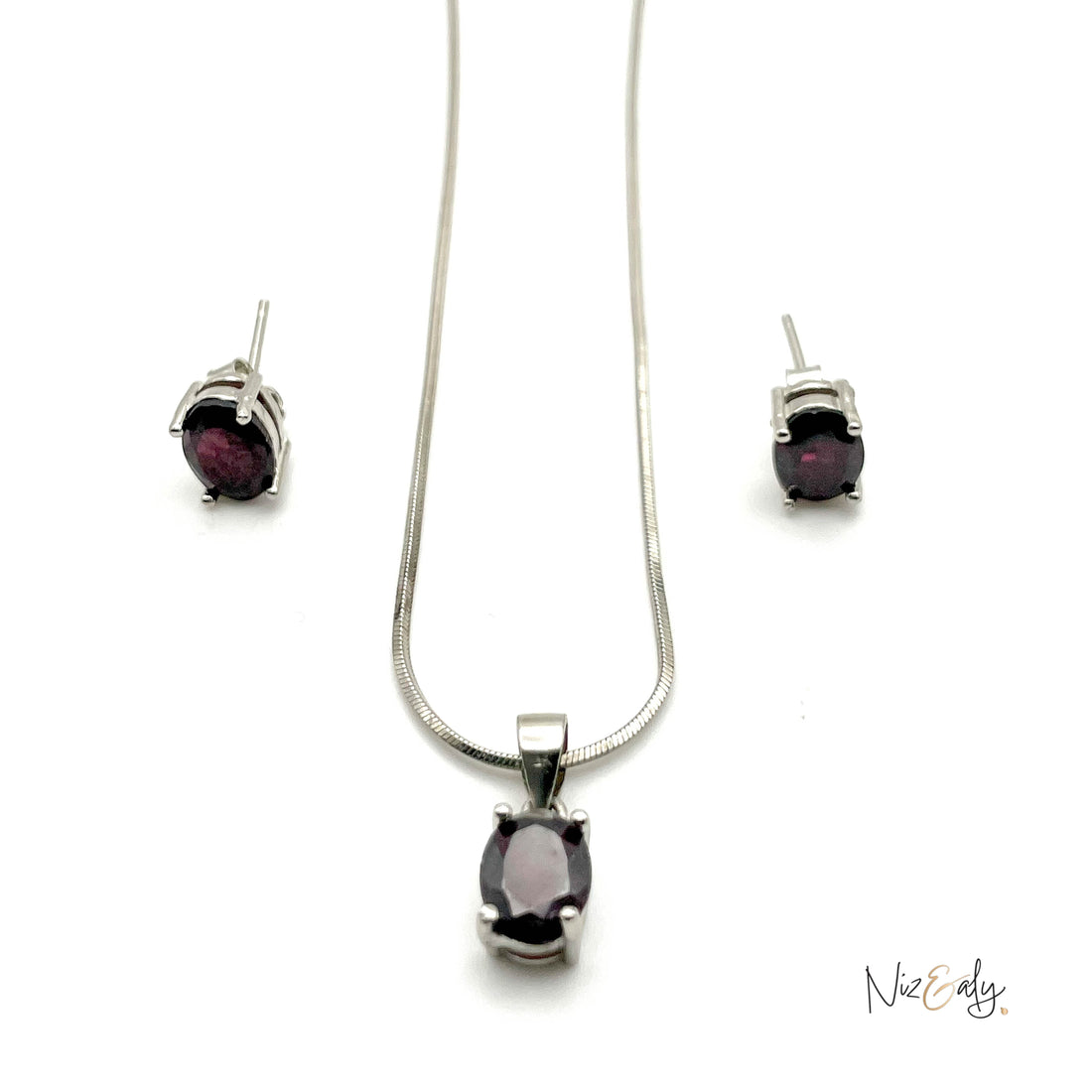 Niz & Aly garnet locket necklace and matching stud earrings set in silver with deep red oval gemstones.