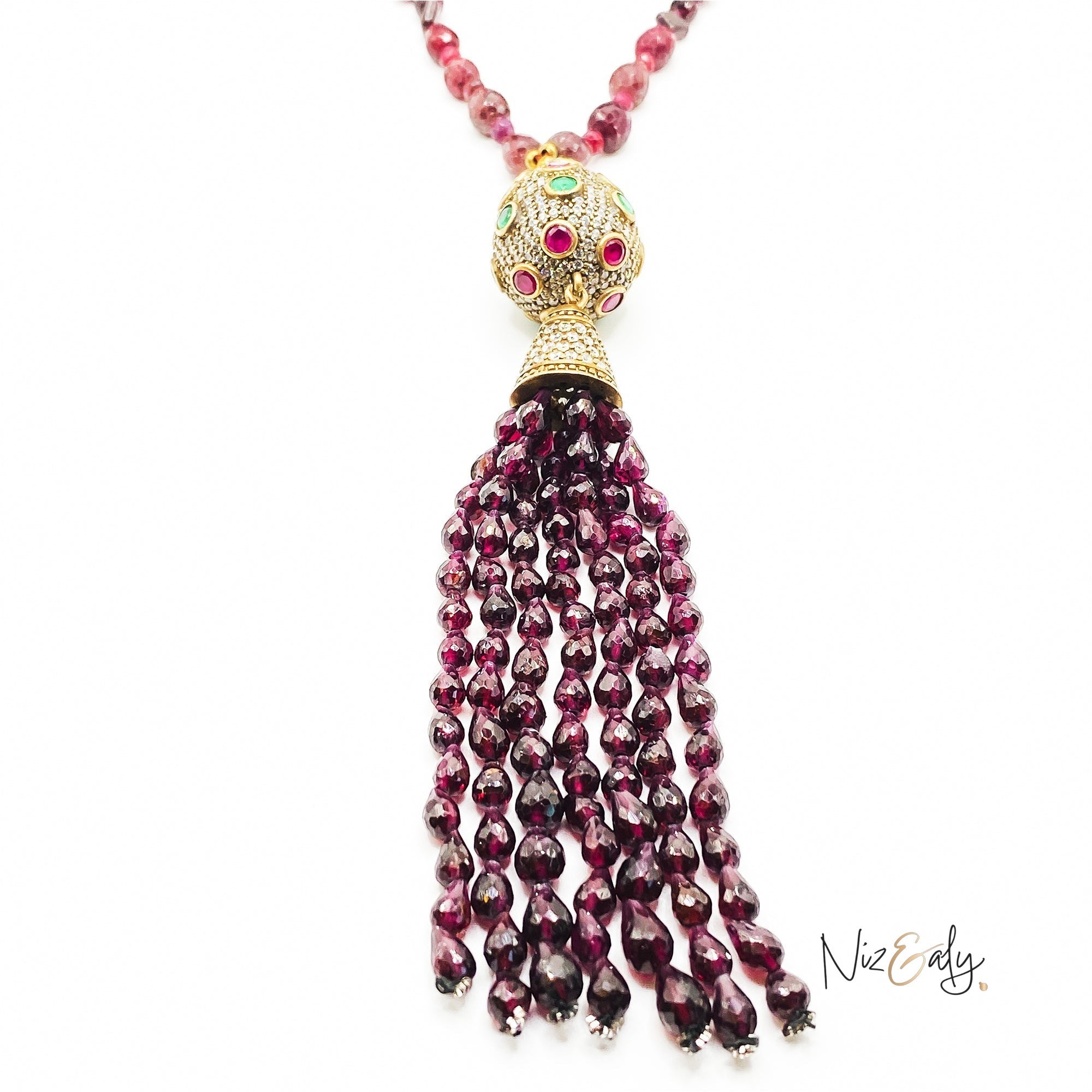 Niz & Aly Mozambique Almandine garnet tassel necklace featuring ruby and emerald accents in a gold-tone setting.