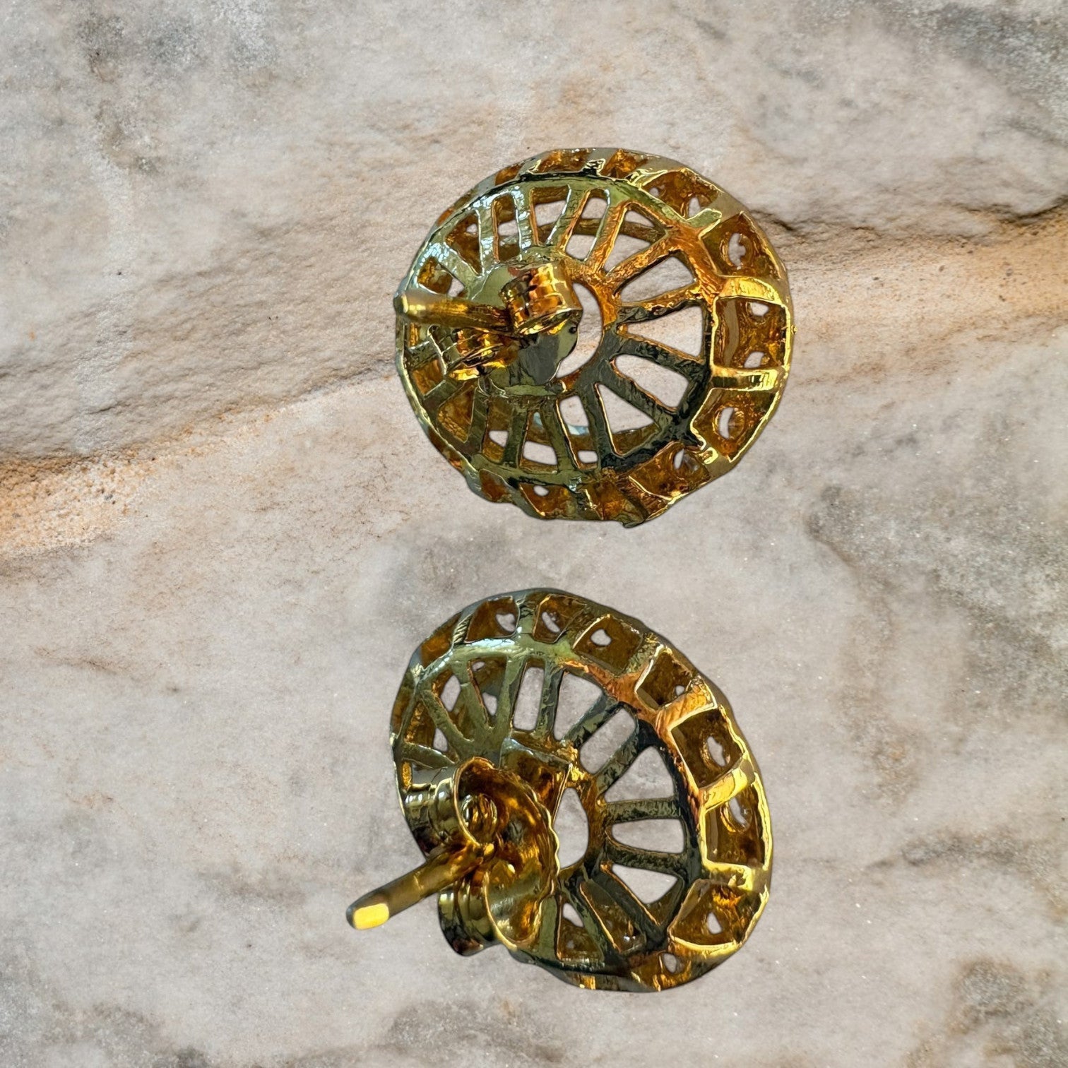 Niz & Aly aquamarine halo stud earrings showing the intricate gold filigree back design on a textured stone surface.