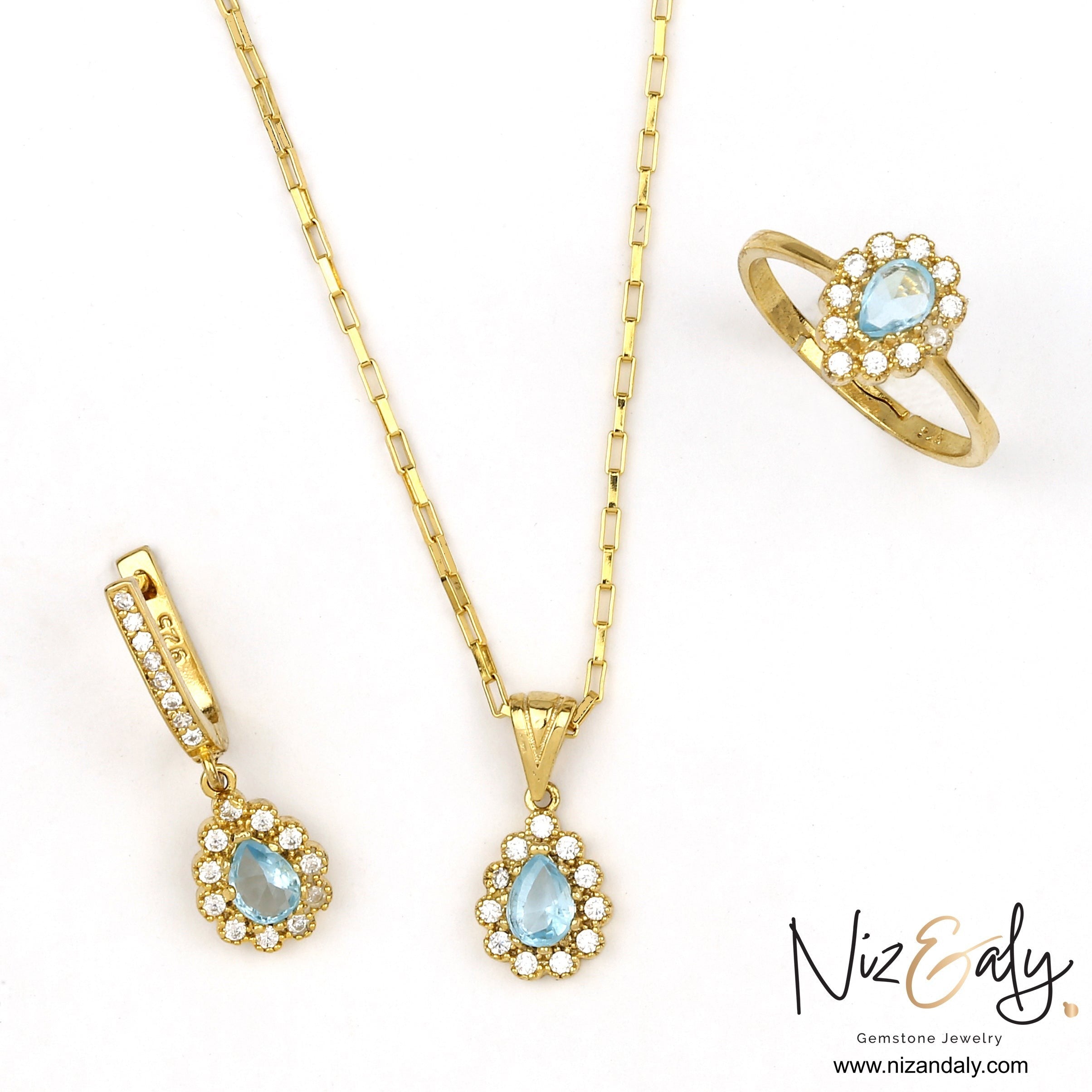 Niz & Aly gold plated jewelry set featuring pear-shaped natural blue topaz stones surrounded by sparkling white crystals