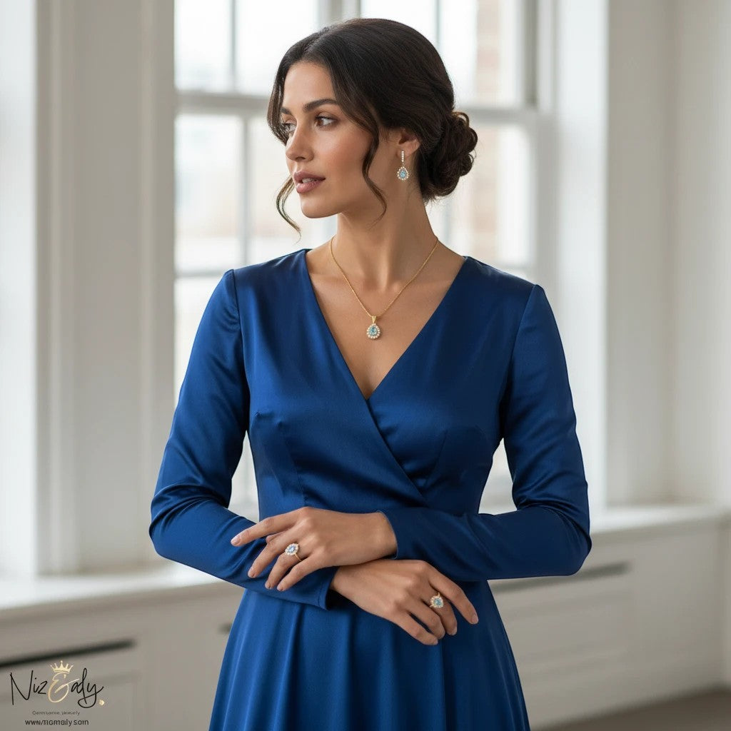 Niz & Aly gold plated jewelry set featuring pear-shaped natural blue topaz pendant, earrings, and rings on a model