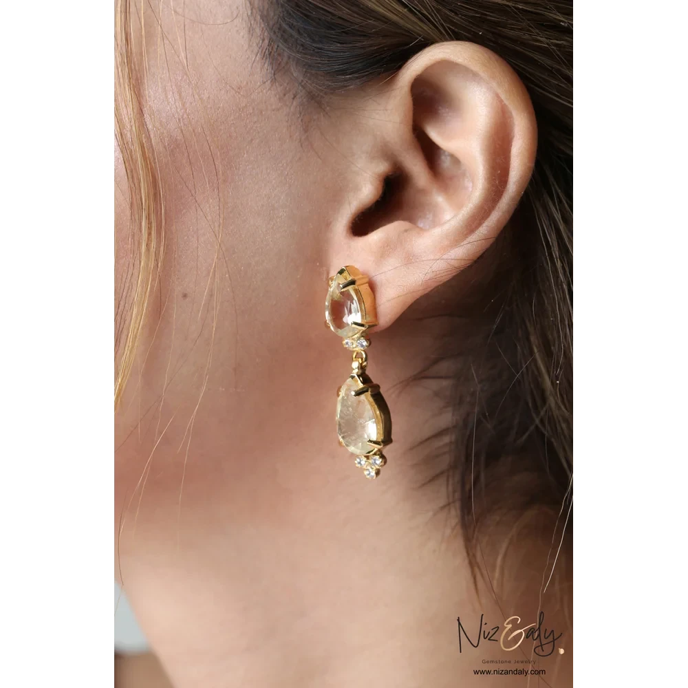 Niz & Aly gold-plated sterling silver teardrop clear quartz earrings worn on a woman's ear