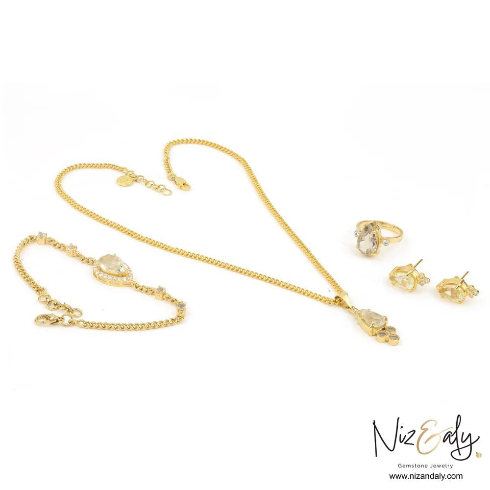 Niz & Aly gold-plated 925 silver jewelry set featuring teardrop clear quartz stones in a necklace, bracelet, and ring.