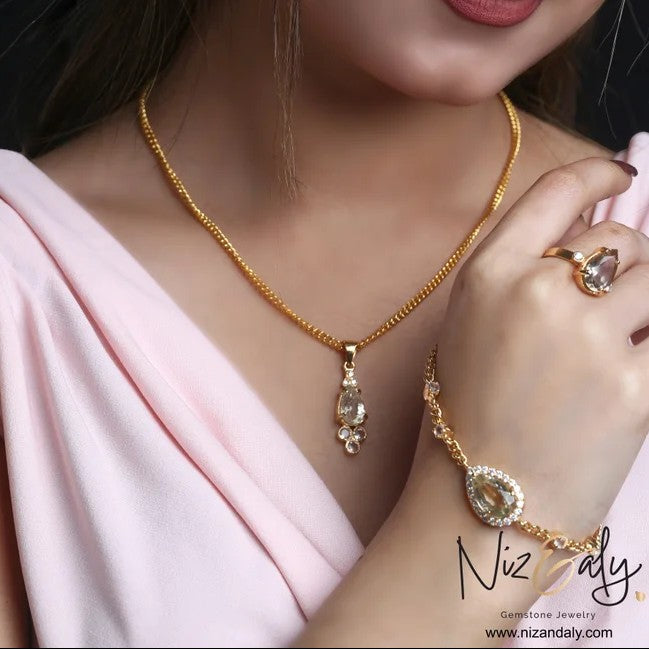 Niz & Aly gold-plated 925 silver jewelry set featuring clear quartz teardrop necklace, bracelet, and matching ring.
