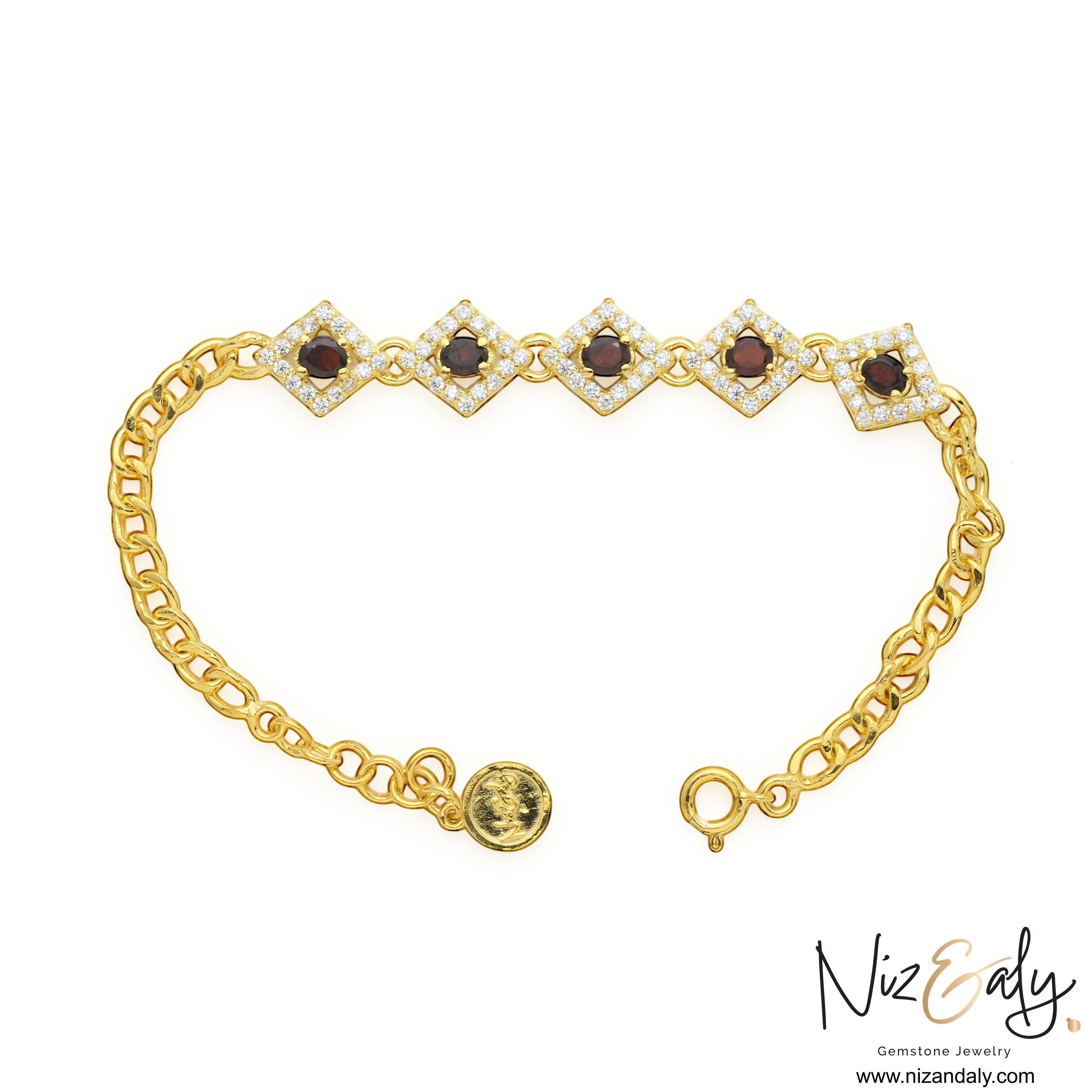 Niz & Aly 14K gold plated silver bracelet featuring diamond-shaped links with red garnet stones and white halos.