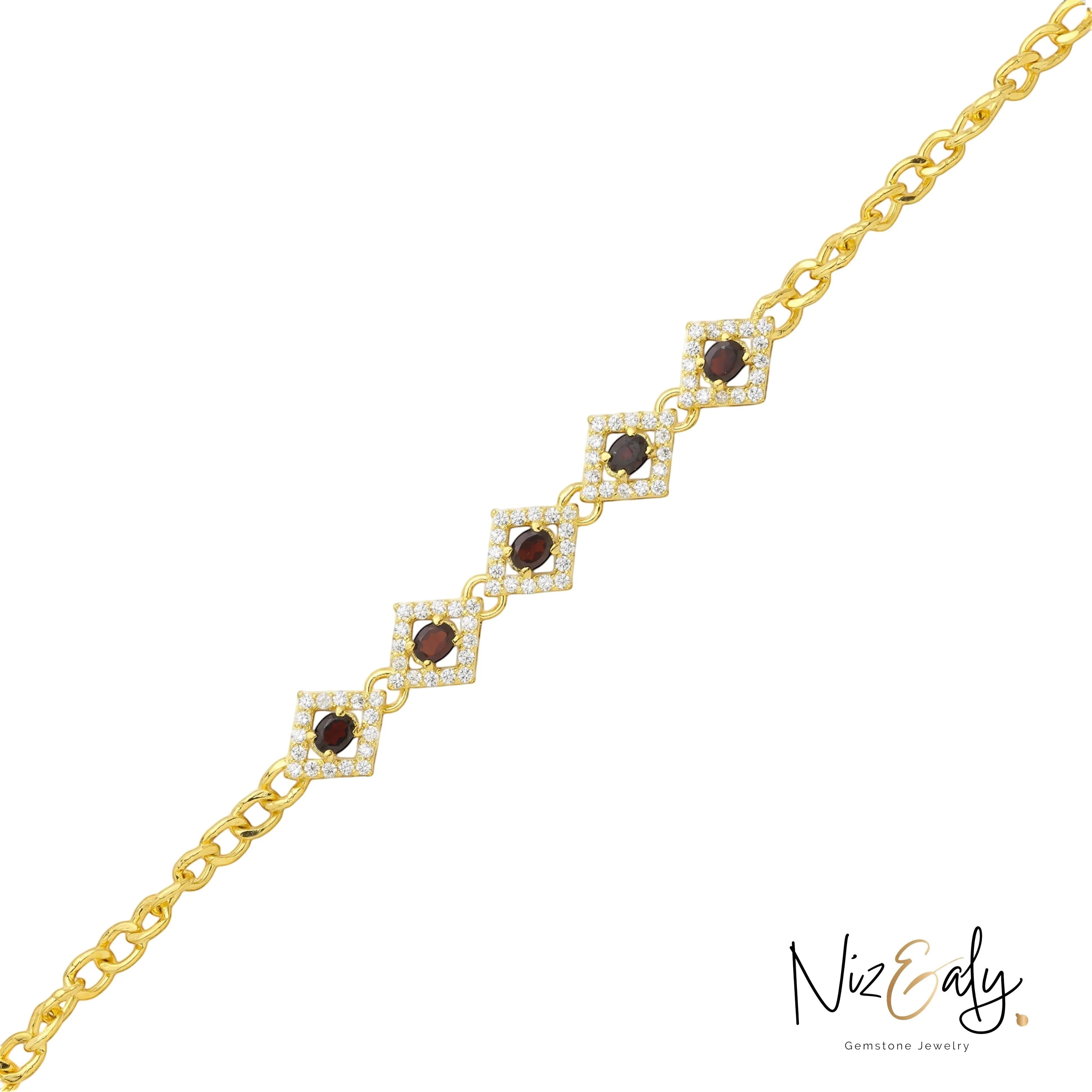 Niz & Aly 14K gold-plated silver bracelet featuring diamond-shaped links with deep red garnet stones and crystal halos.