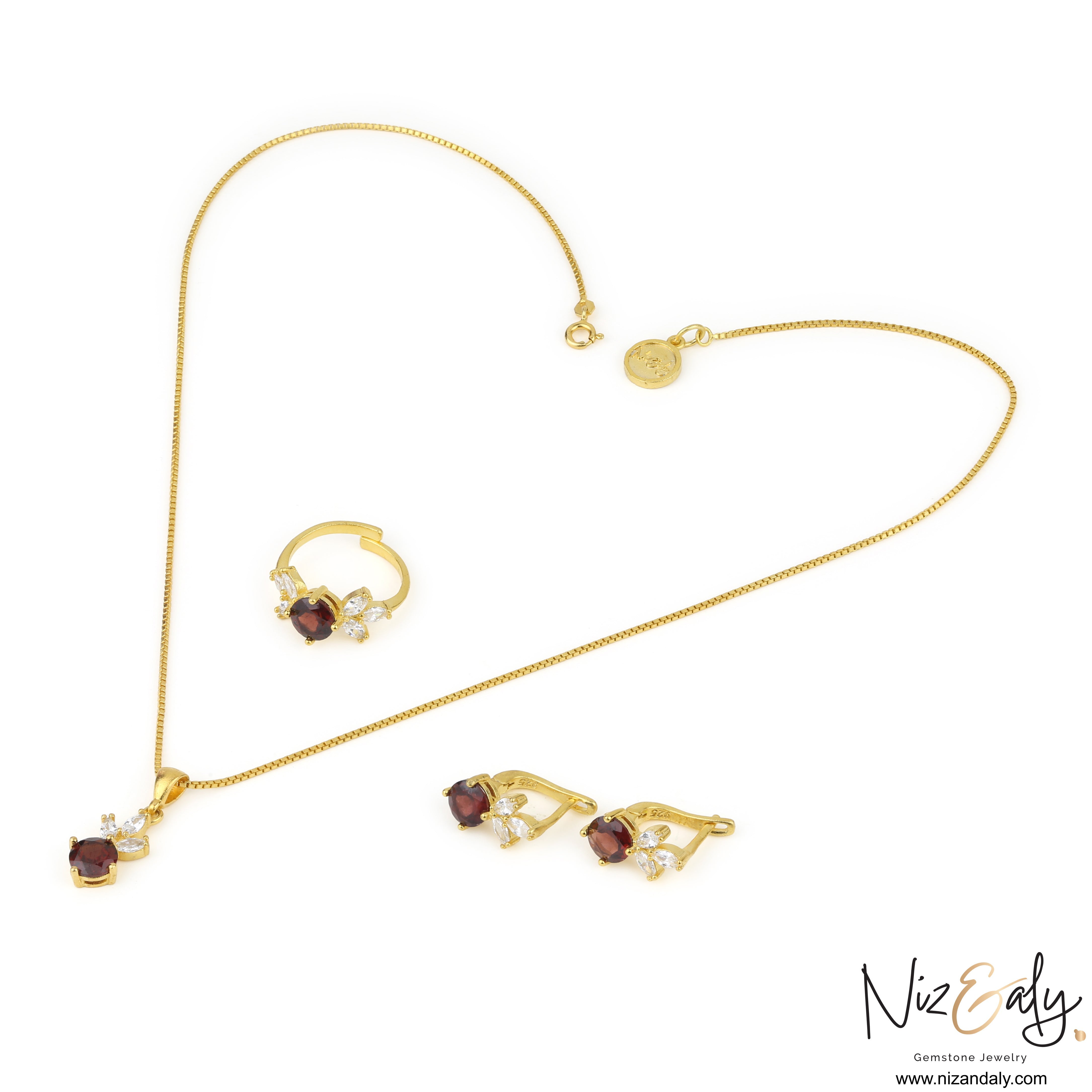 Niz & Aly gold jewelry set featuring natural garnet stones and clear accent crystals on a necklace, ring, and earrings.