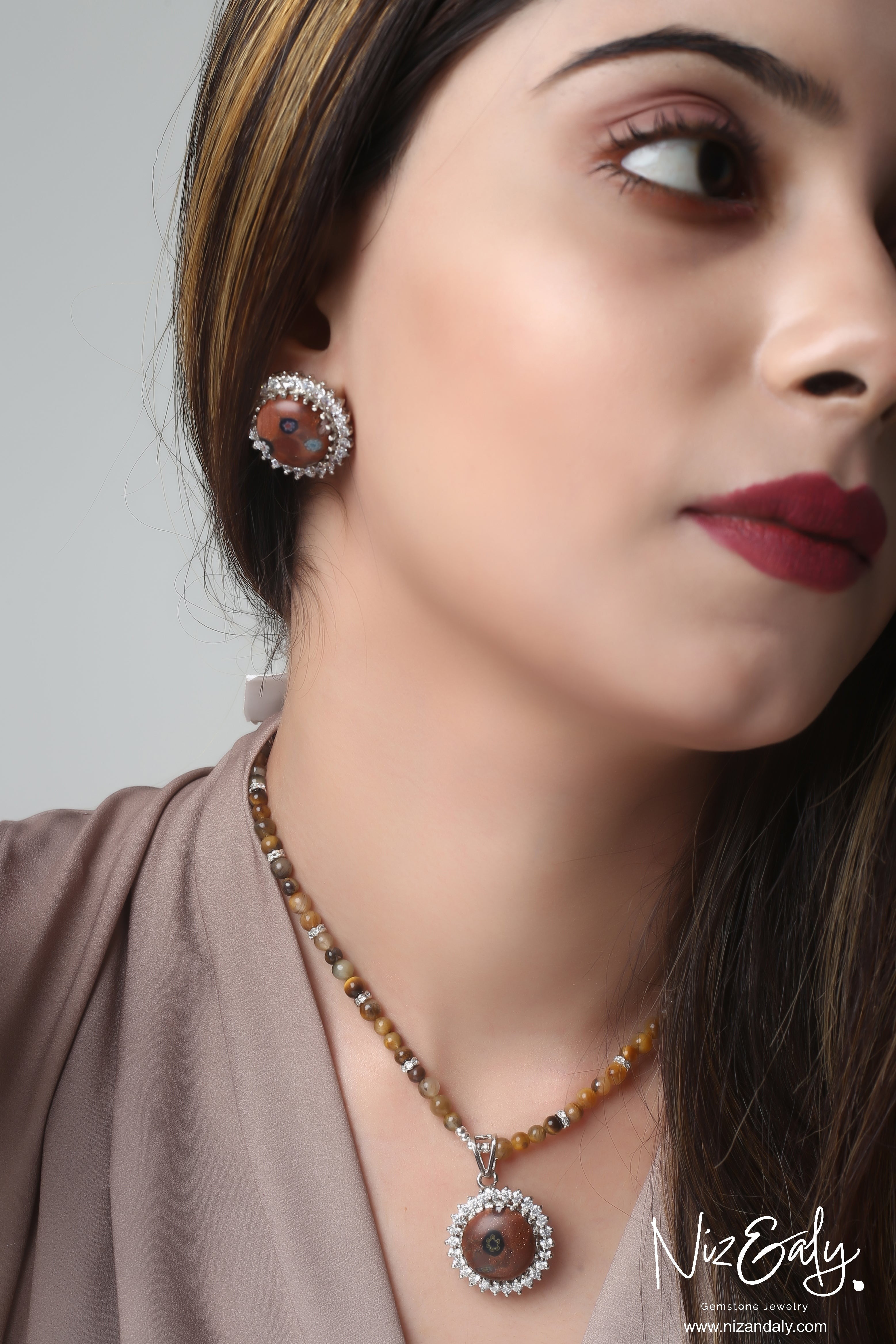 Niz & Aly gold orgonite pendant necklace and matching stud earrings with polished brown tiger's eye beads on a model