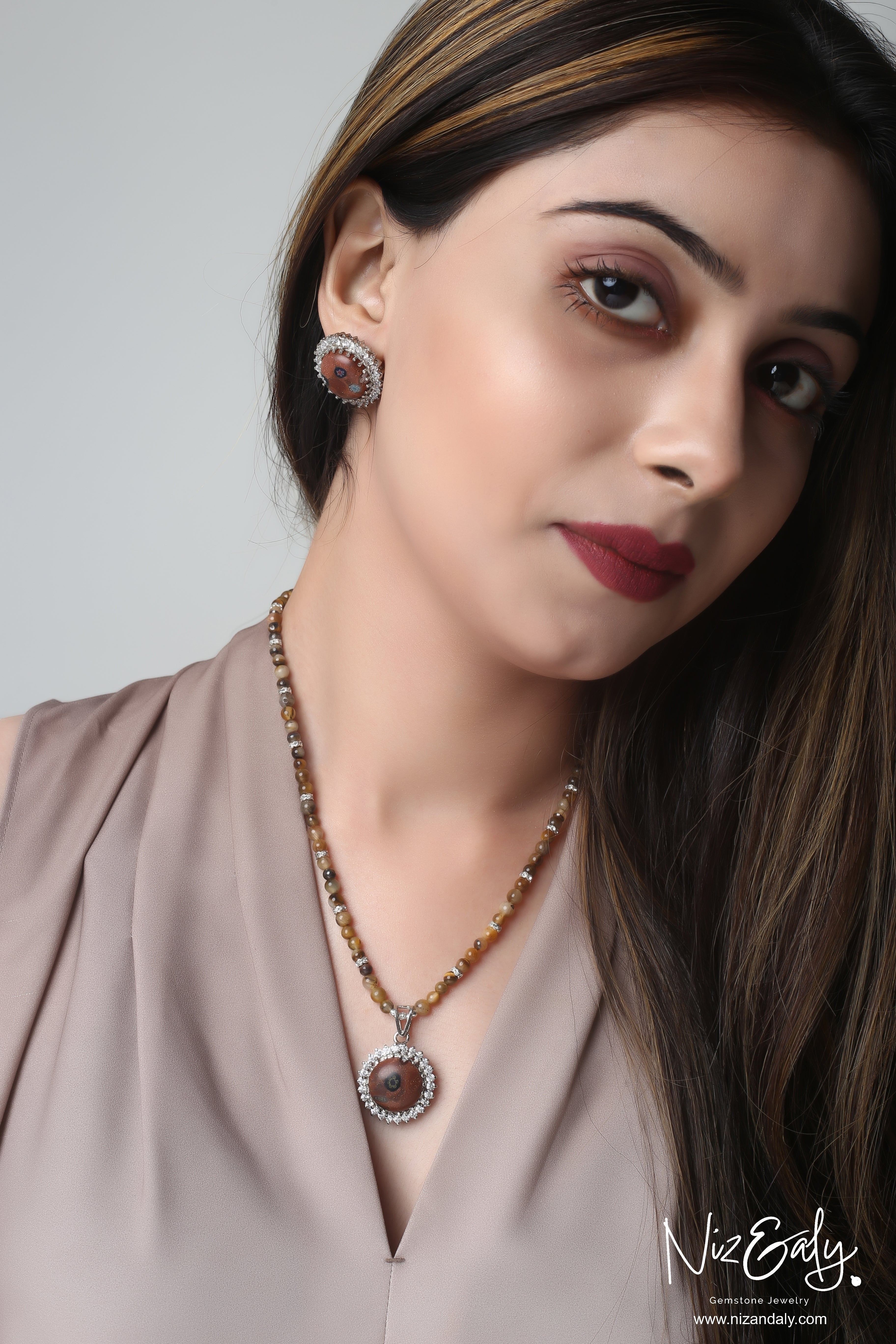 Niz & Aly gold orgonite pendant necklace with tiger's eye beads and matching earrings worn by a model
