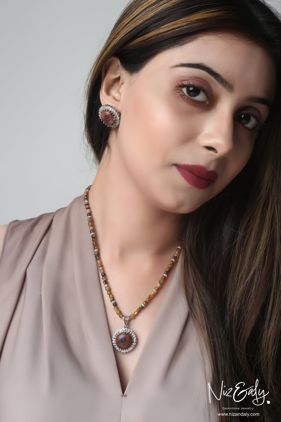 Niz & Aly gold orgonite pendant necklace with tiger's eye beads and matching earrings worn by a model