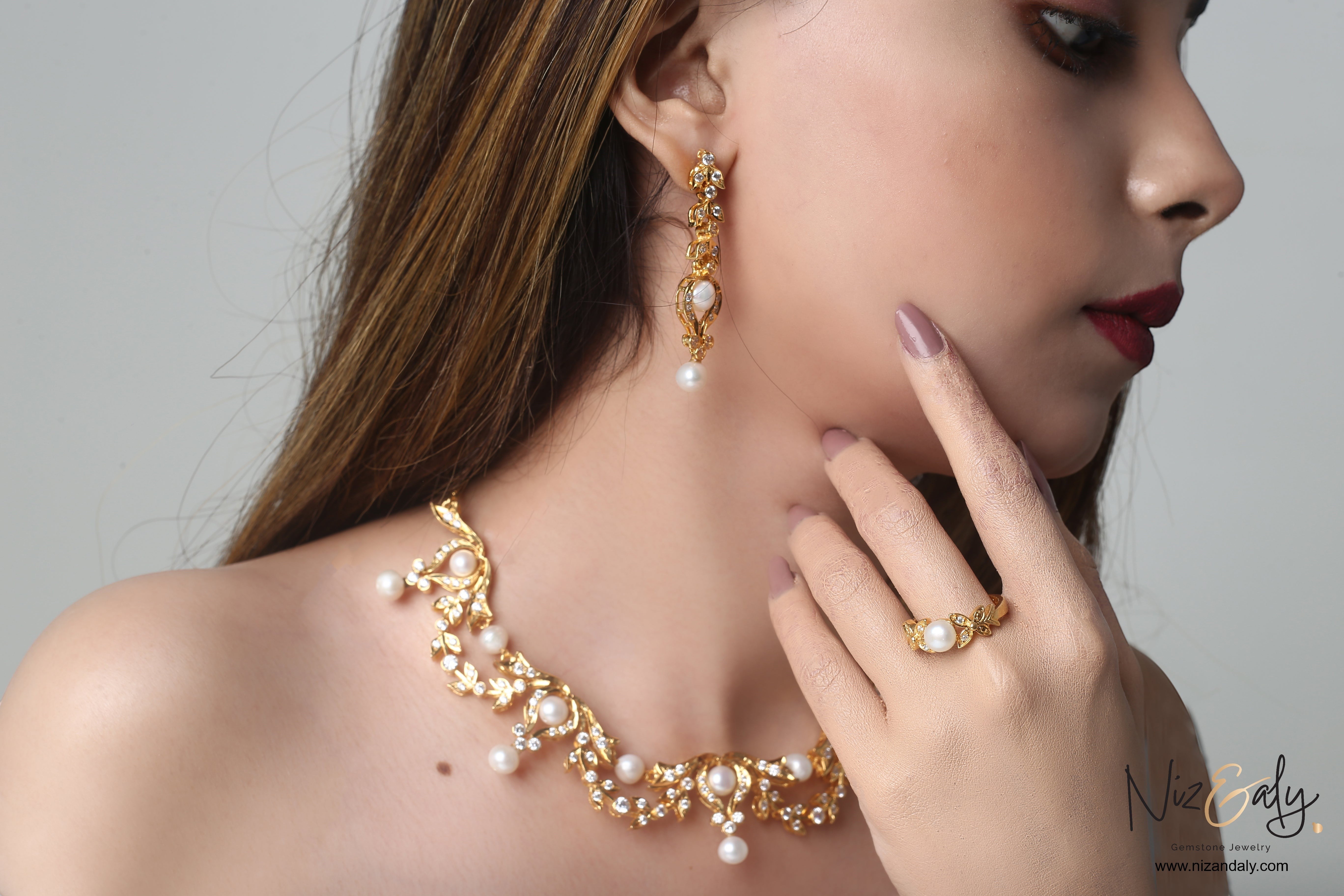 Niz & Aly bridal gold-plated sterling silver necklace set with freshwater pearls and matching earrings on a model