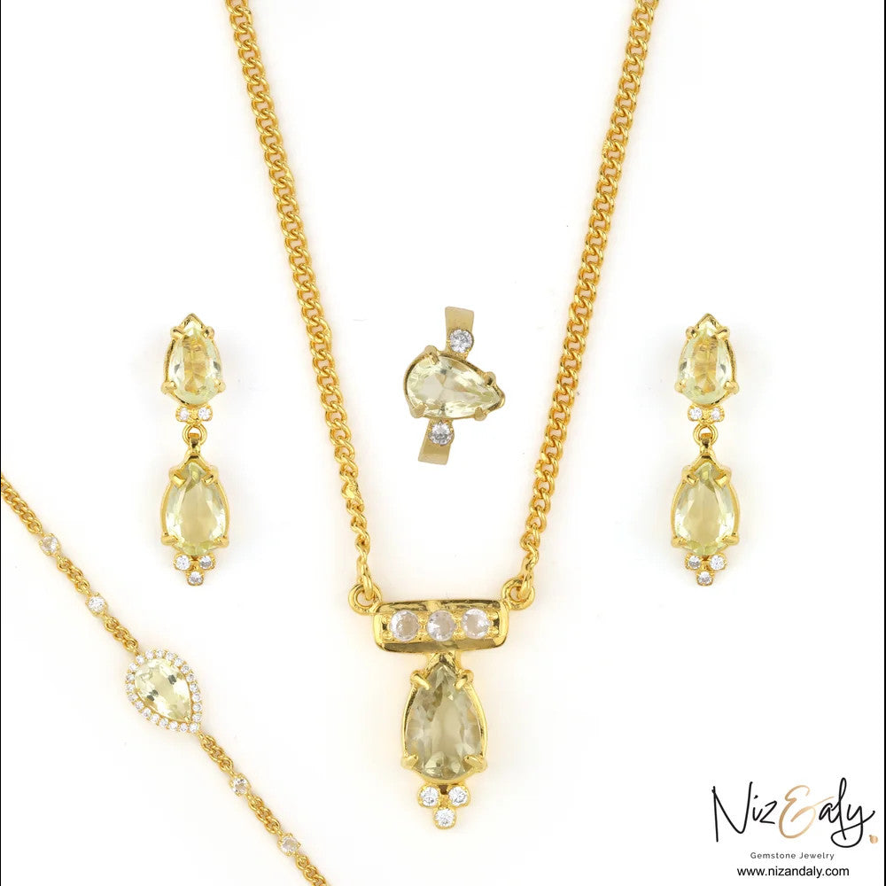 Niz & Aly gold-plated sterling silver jewelry set featuring teardrop clear quartz stones and delicate crystal accents.