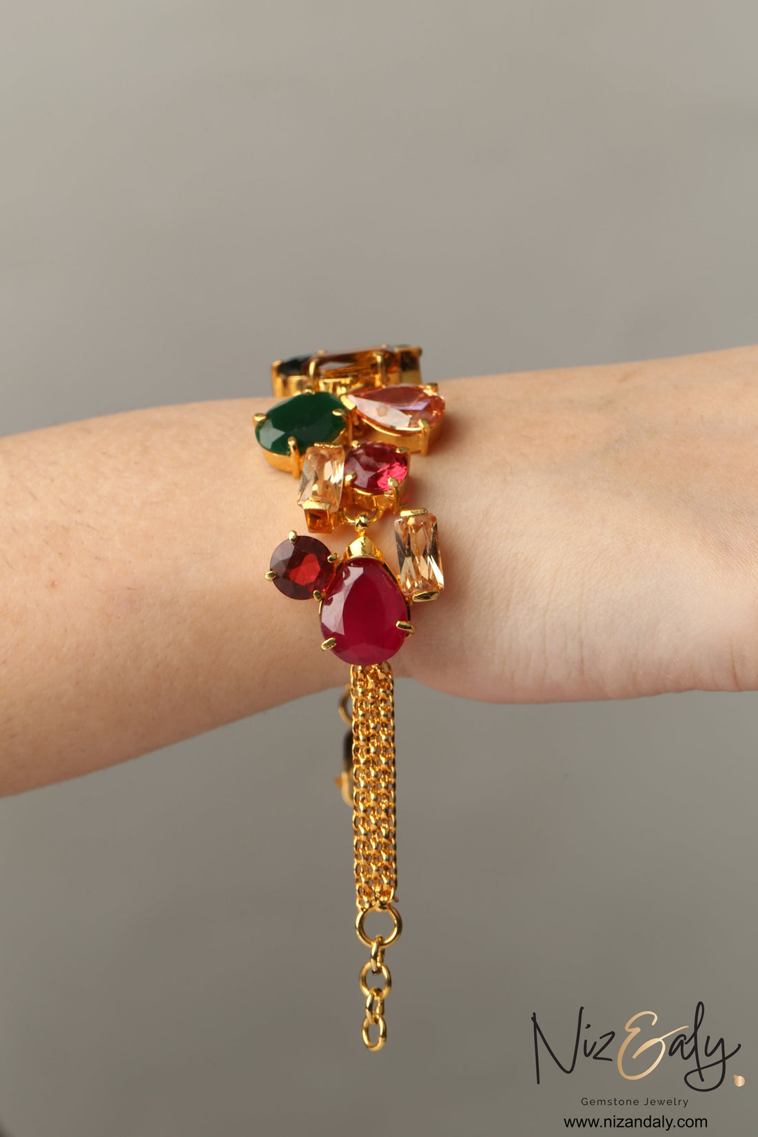 Niz & Aly gold-plated bracelet with pear-shaped composite ruby and multi-colored cubic zirconia stones on a chain.