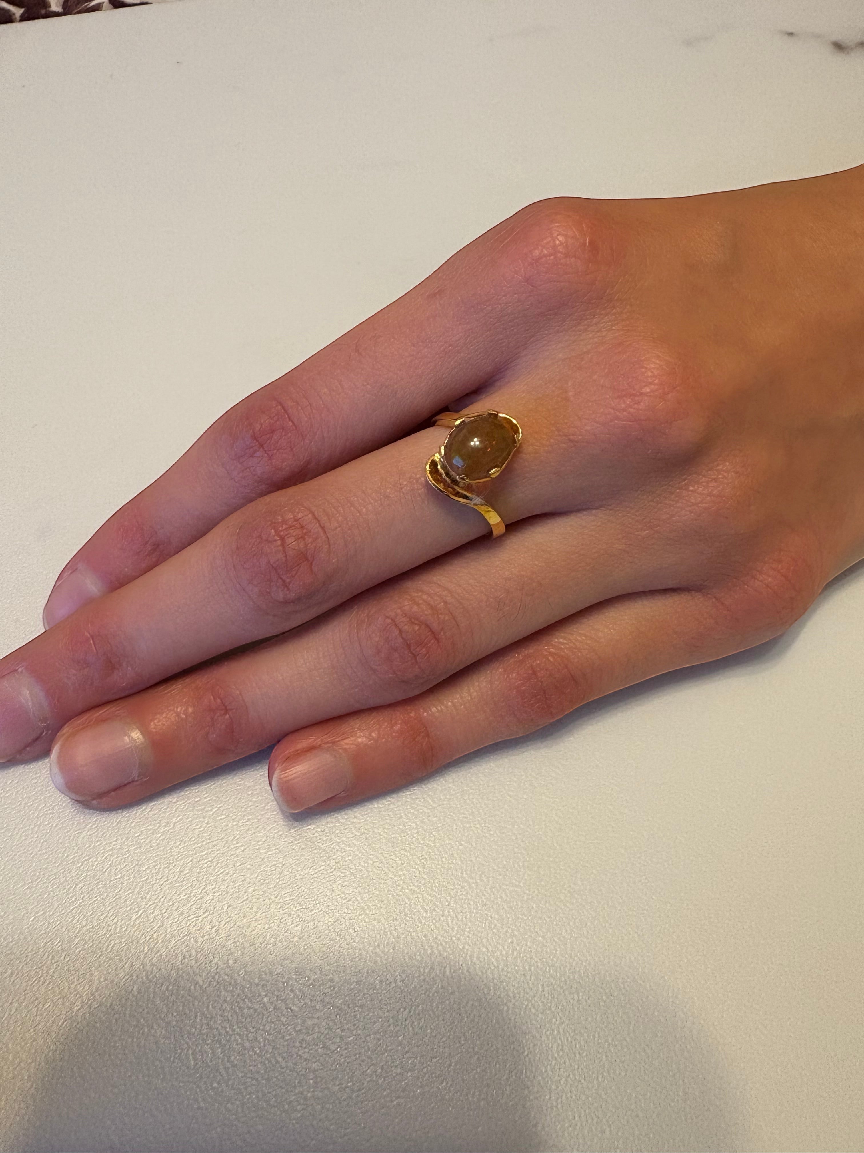 Niz & Aly adjustable ring featuring a golden fire opal set in gold-plated sterling silver on a woman's finger.