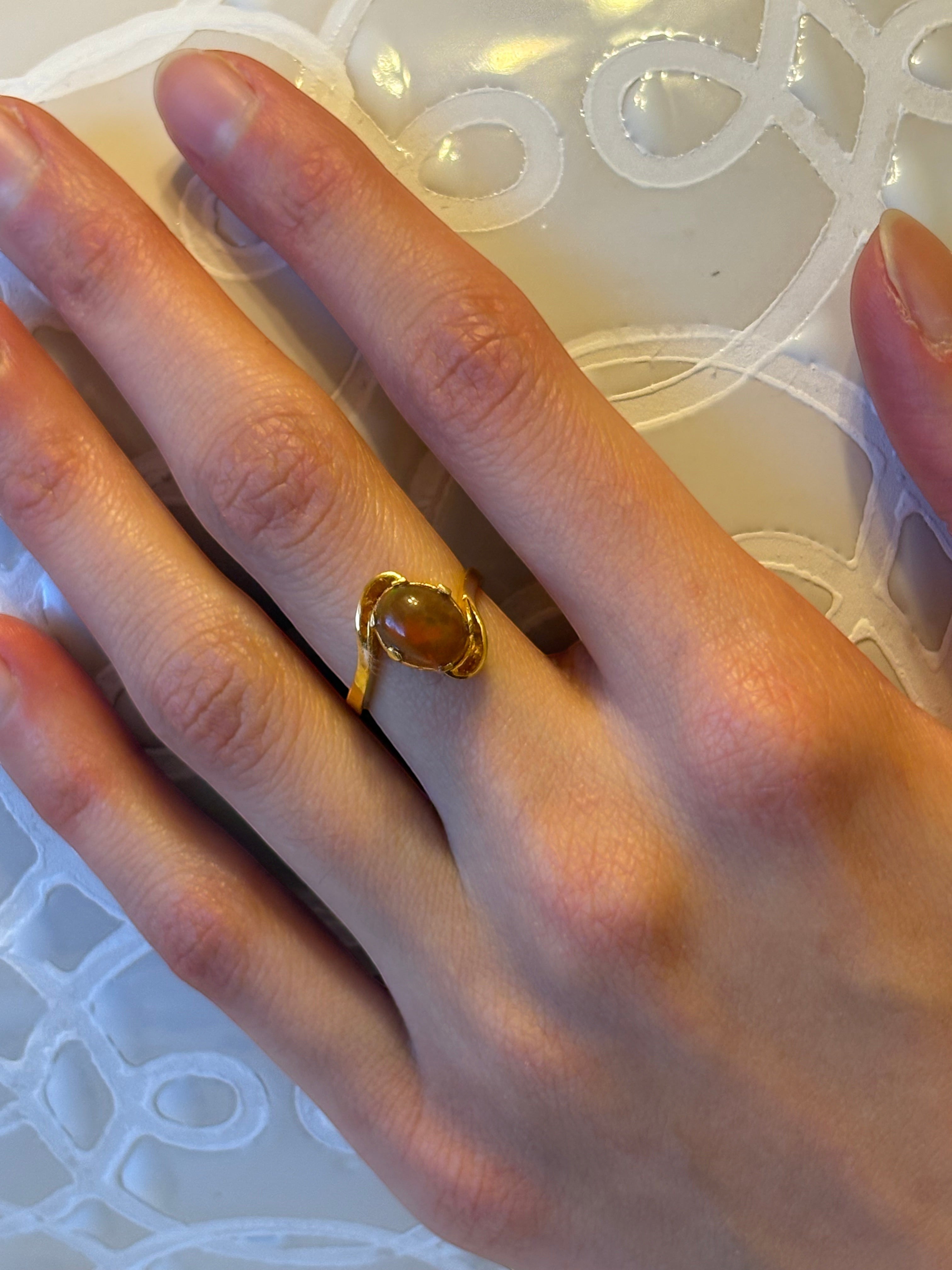 Niz & Aly golden fire opal adjustable ring in gold-plated sterling silver worn on a finger