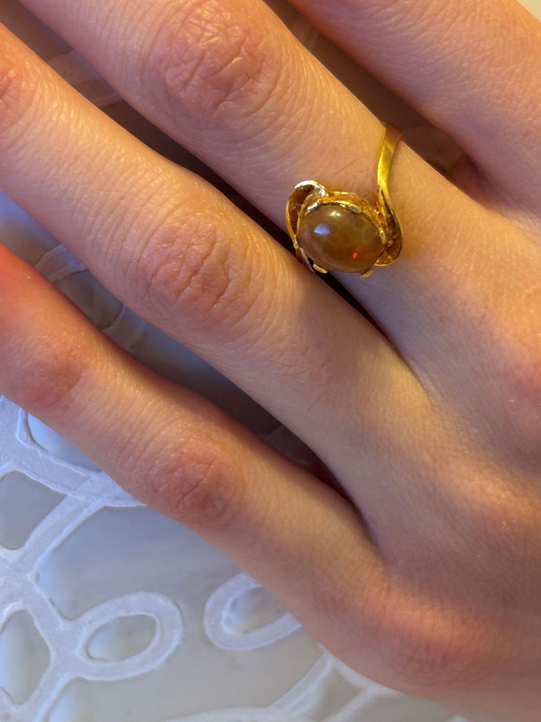 Niz & Aly adjustable ring featuring a golden fire opal set in gold-plated sterling silver on a finger.