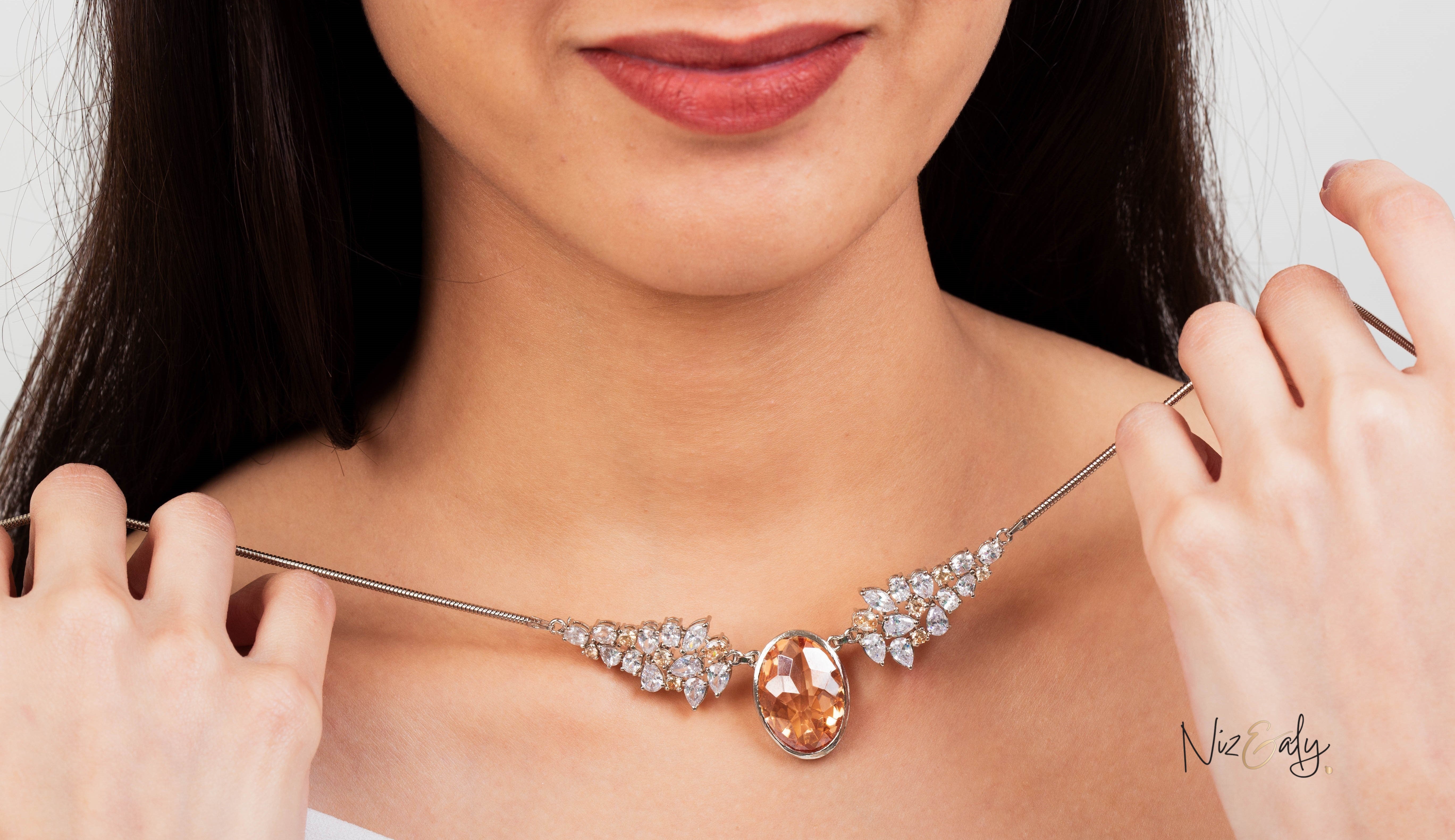 Niz & Aly Golden Hour statement necklace featuring a champagne-hued oval zirconia pendant with clear crystal accents