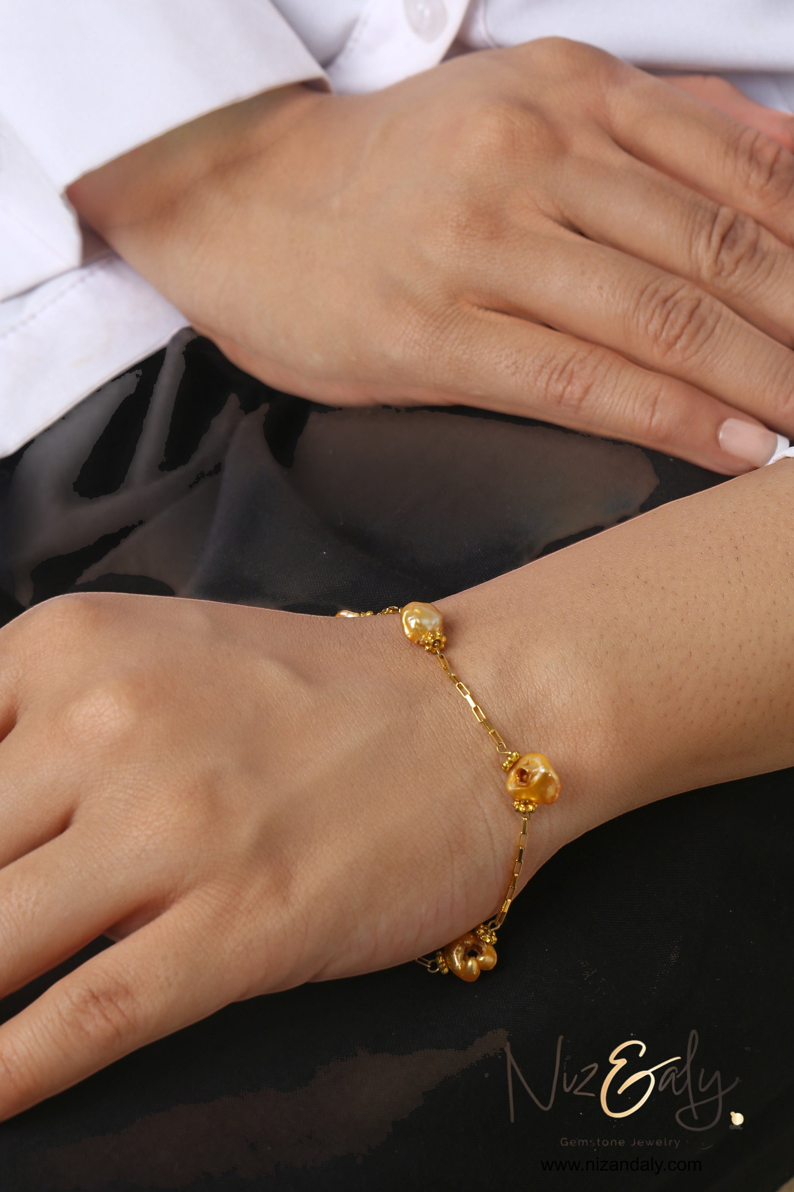 Niz & Aly golden freshwater pearl bracelet on a sterling silver gold-plated chain worn on a wrist